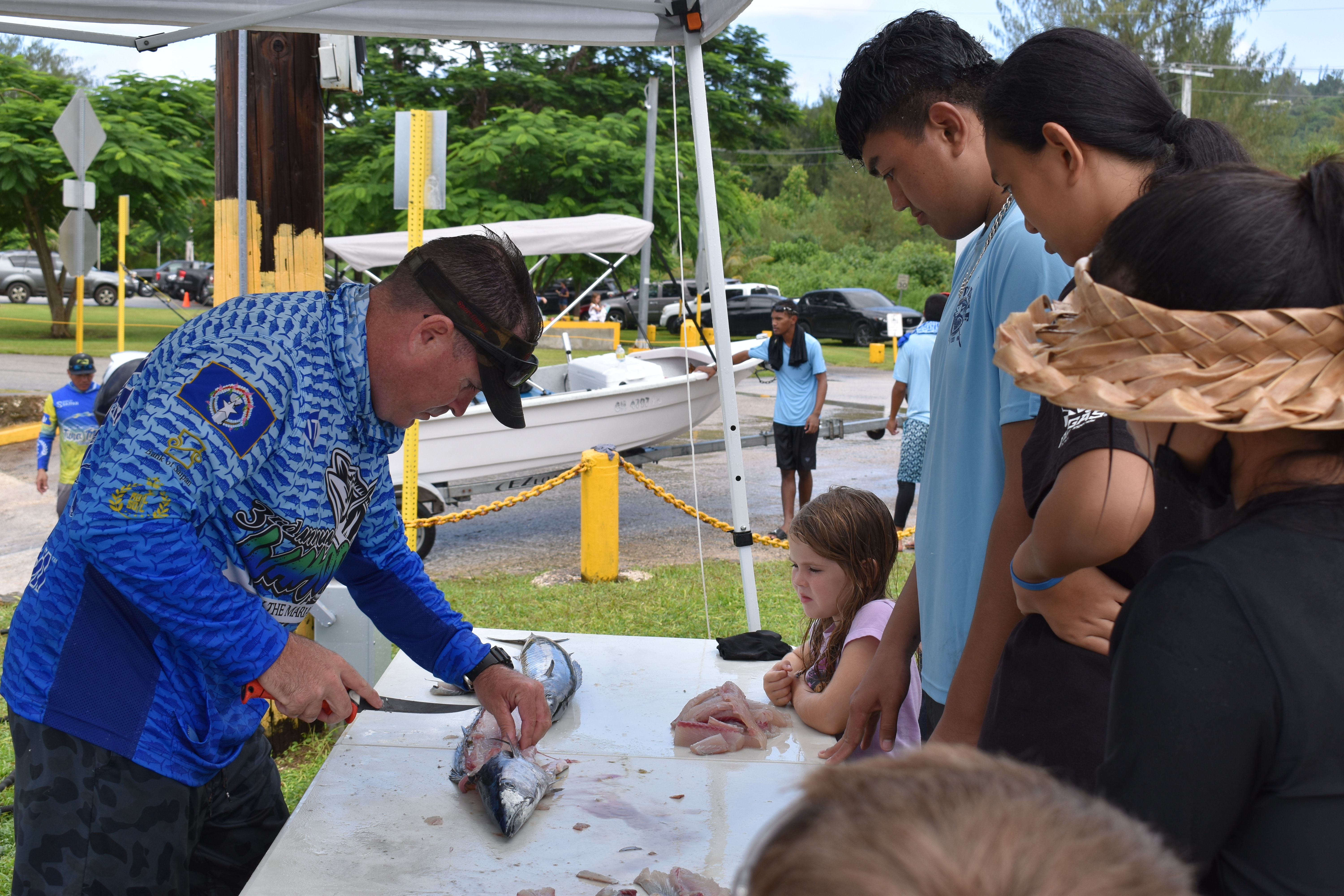 Boat Captain Albert “Bubba” Flores teaches students how to filet a fish during the Tasi To Table Student Mini-Derby Saturday at Smiling Cove Marina.