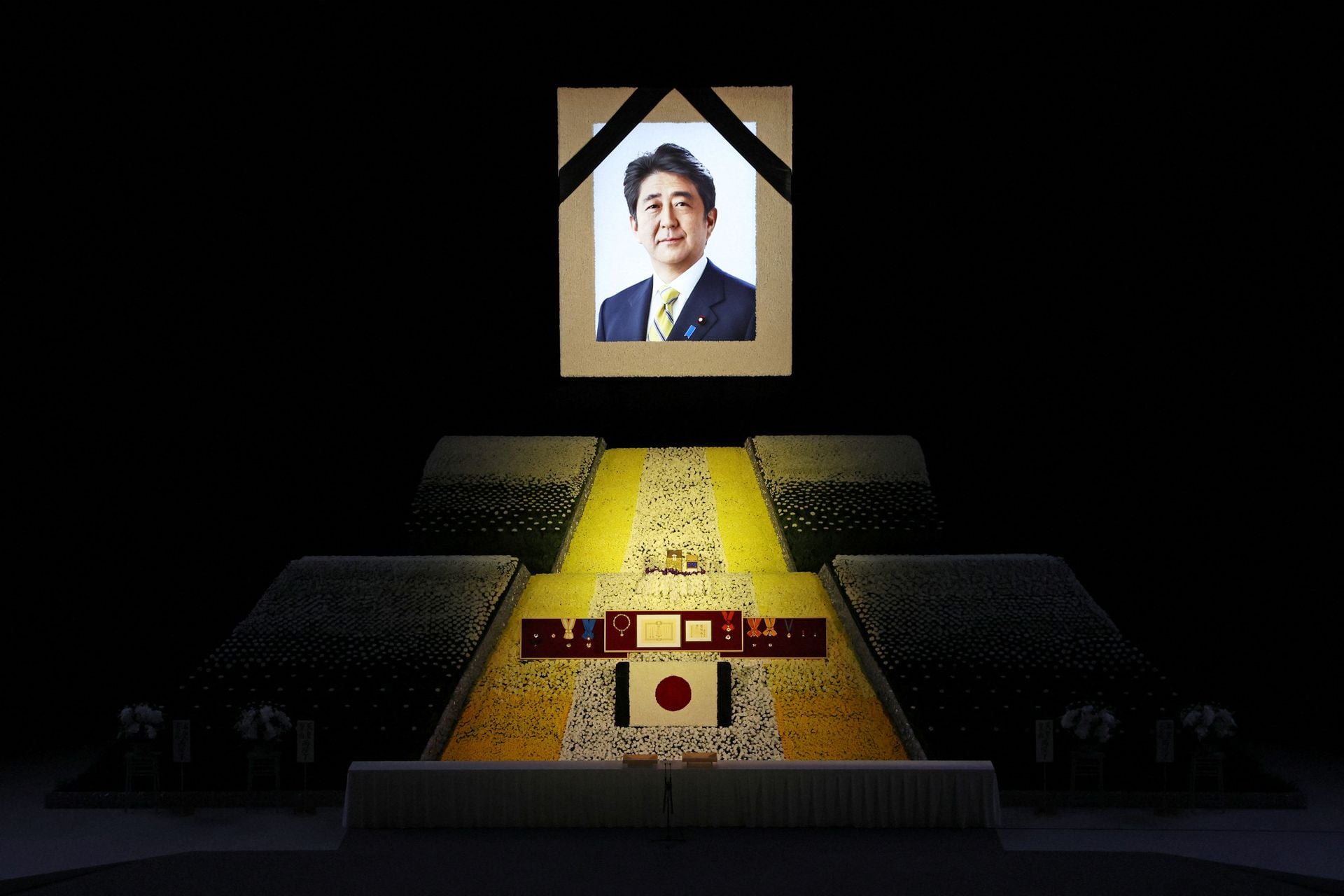 A portrait of Shinzo Abe hangs in front of the stage during the state funeral for Japan's former prime minister on Sept. 27, 2022 at the Budokan in Tokyo, Japan. Several current and former heads of state visited Japan for the state funeral of Abe, who was assassinated in July while campaigning on a street.