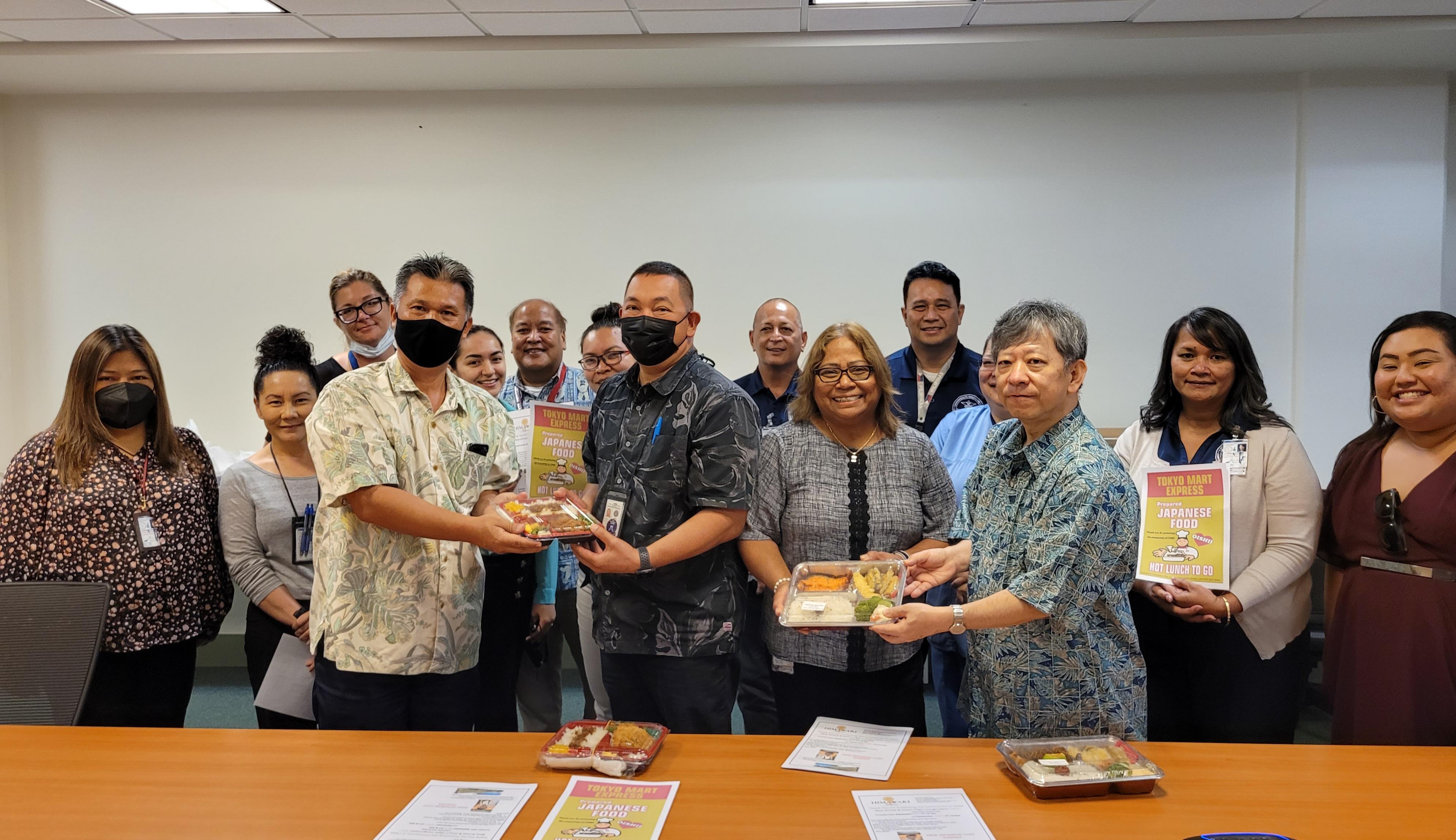 Japanese Consul Ryogi Takagagi and Japanese Society of NMI Chairman Mamoru Watanabe hand bento boxes to CHCC CEO Esther Muna and CHCC chief of ancillary services Jesse Tudela in the CHCC conference room on Wednesday. Also in photo are  CHCC staffers.