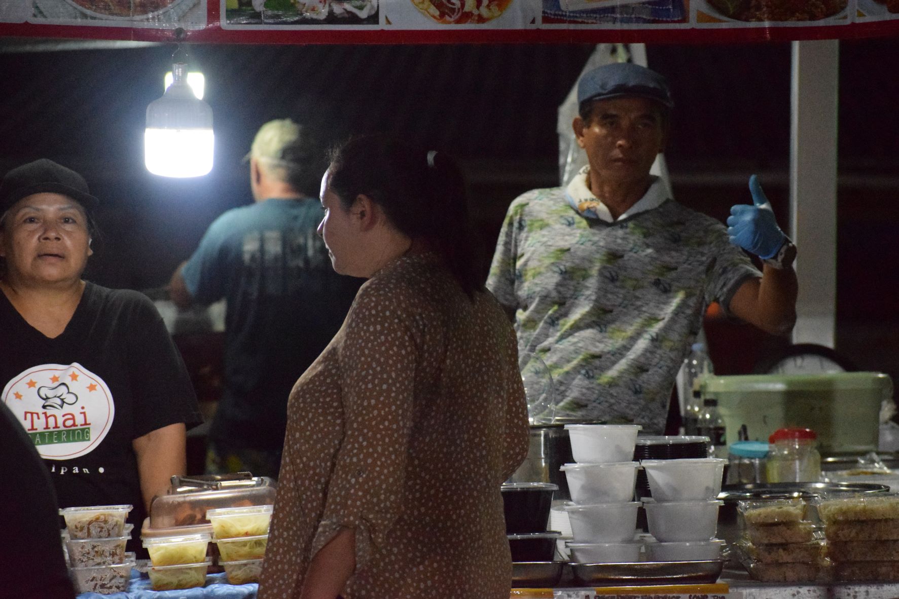 Mini Thai Catering food servers attend to a customer.