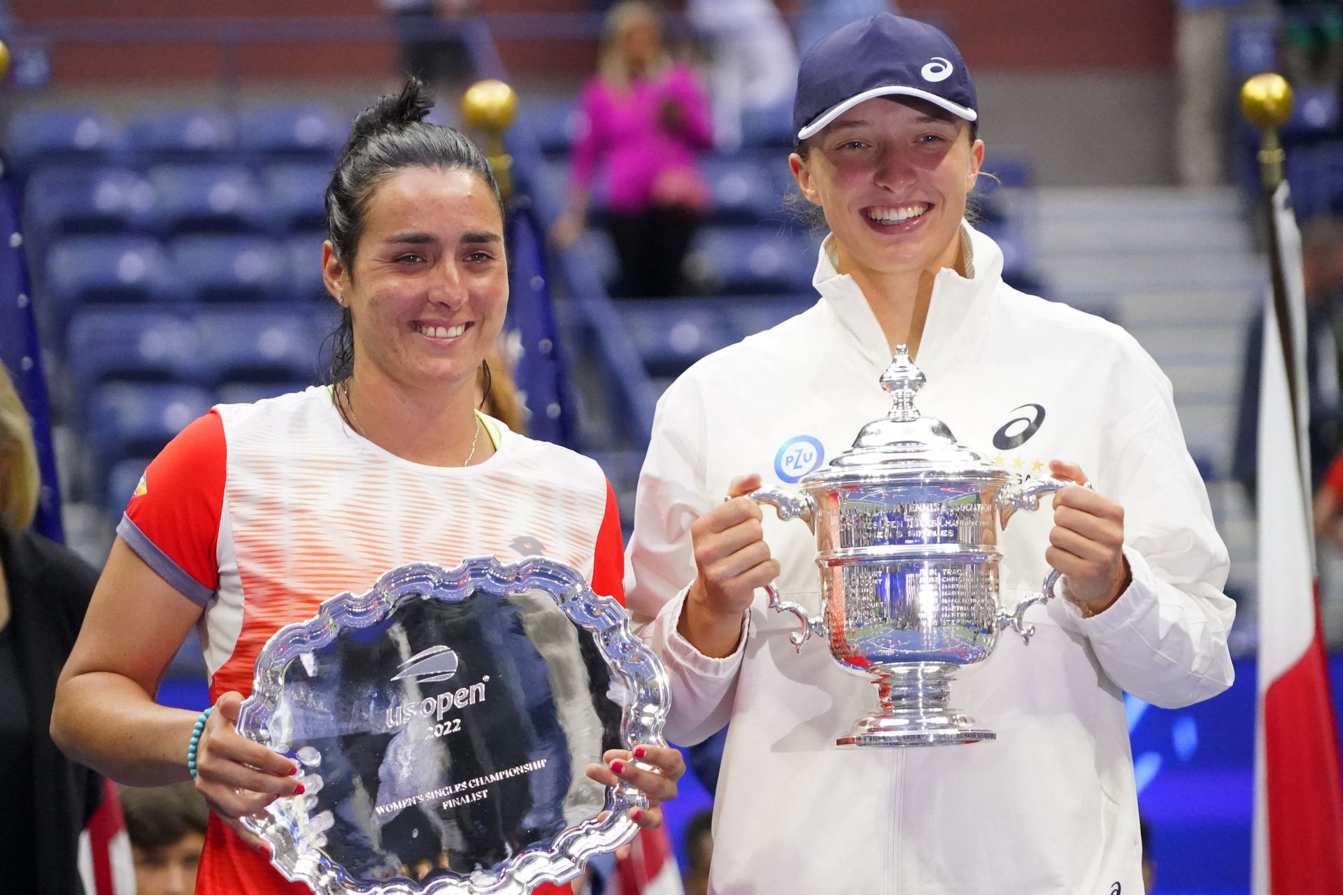 Ons Jabeur, left, and Iga Swiatek  hold the finalist and championship trophies, respectively, after their match in the women's singles final on day 13 of the 2022 U.S. Open tennis tournament at USTA Billie Jean King Tennis Center in Flushing, NY, Sept. 10, 2022.