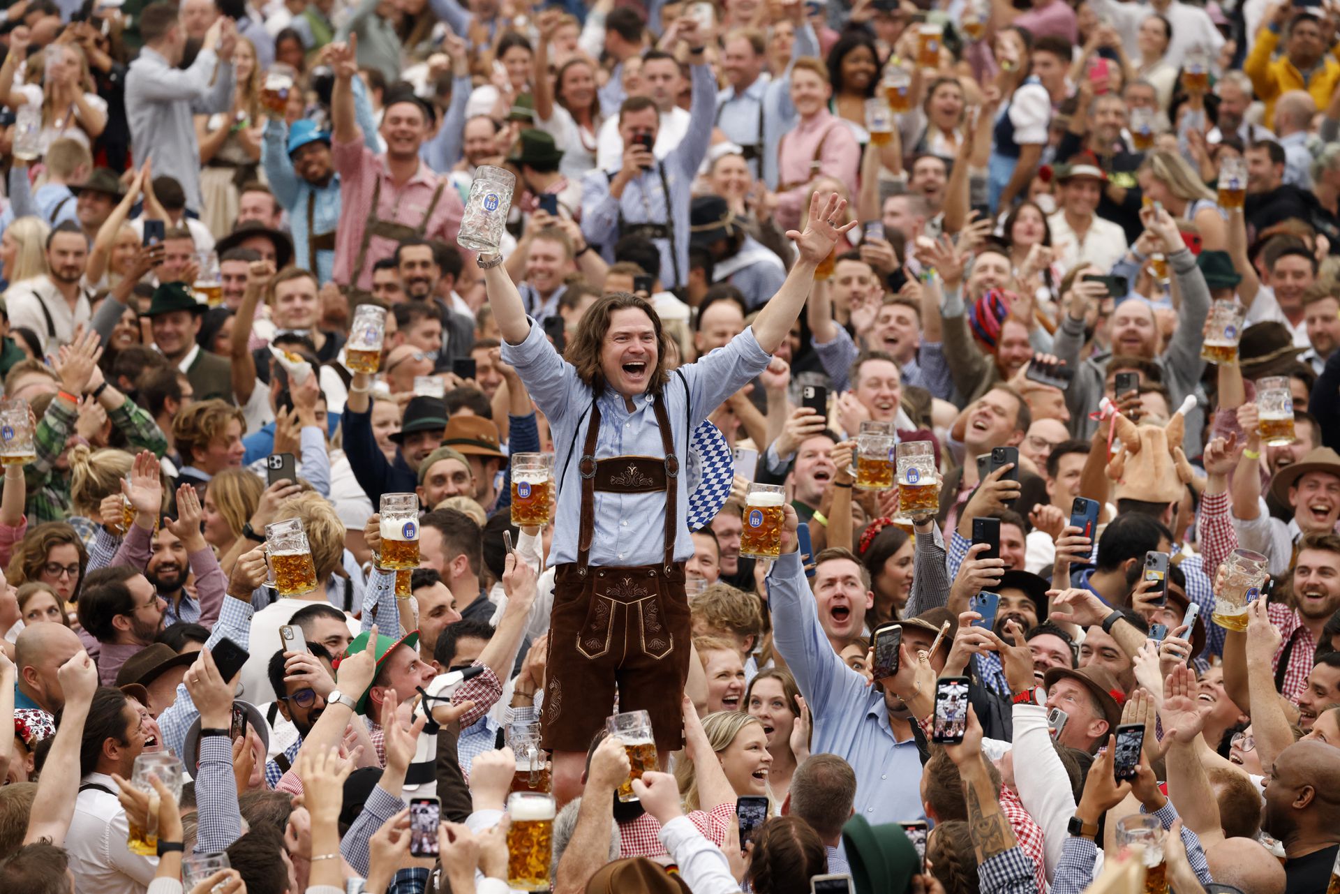 A visitor cheers after finishing a mug of beer during the official opening the world's largest beer festival, the 187th Oktoberfest in Munich, Germany, Sept. 17, 2022.