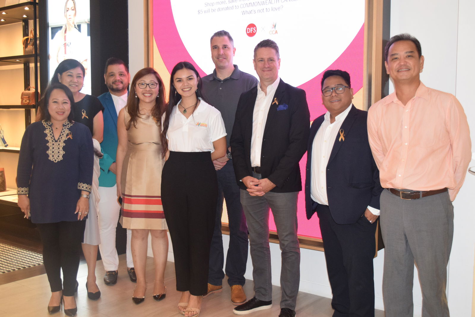 DFS Group in Mid-Pacific, Japan and Korea Managing Director Richard Gustafson, third right, and DFS Consumer Marketing Manager Keiko Nakayama pose for a photo with other DFS officials and special guests during the launching of DFS Cares' charity campaign at the DFS store in Garapan on Friday.