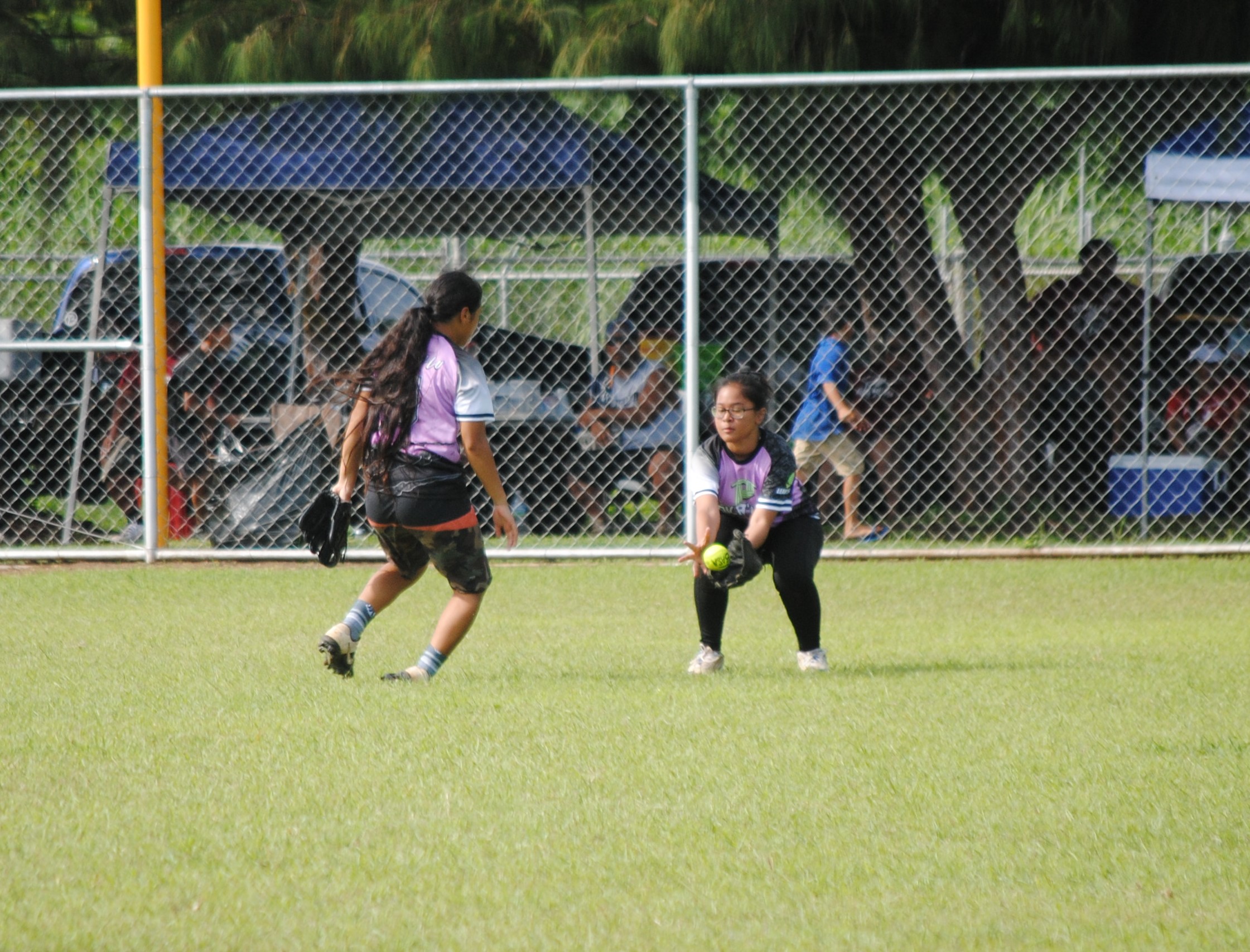 Tokahao Ladies' centerfielder Rayna Deleon Guerrero, right, secures the out during a 2022 Budweiser Belau Amateur Softball League game at the Dandan baseball field.