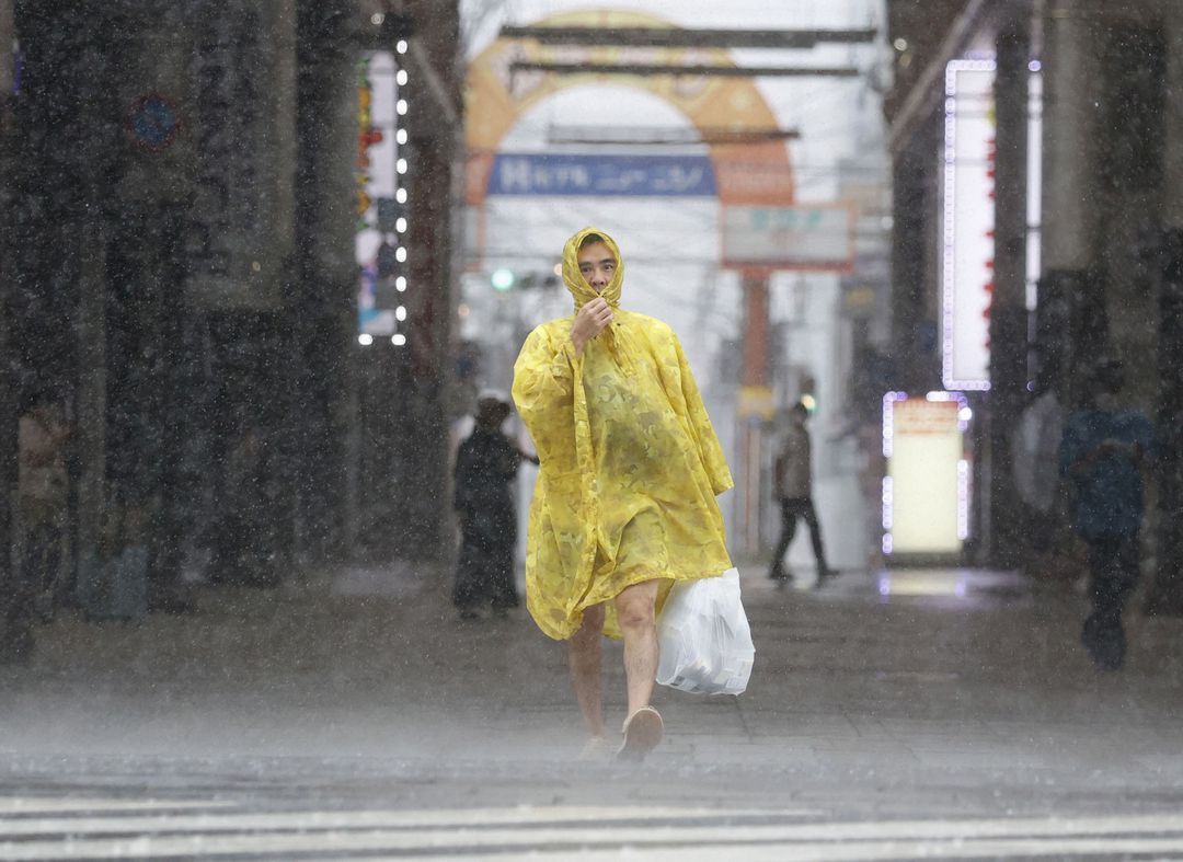 A man walks on the street in heavy rain and wind caused by Typhoon Nanmadol in Kagoshima on Japan's southernmost main island of Kyushu, Sept. 18, 2022, in this photo taken by Kyodo.
