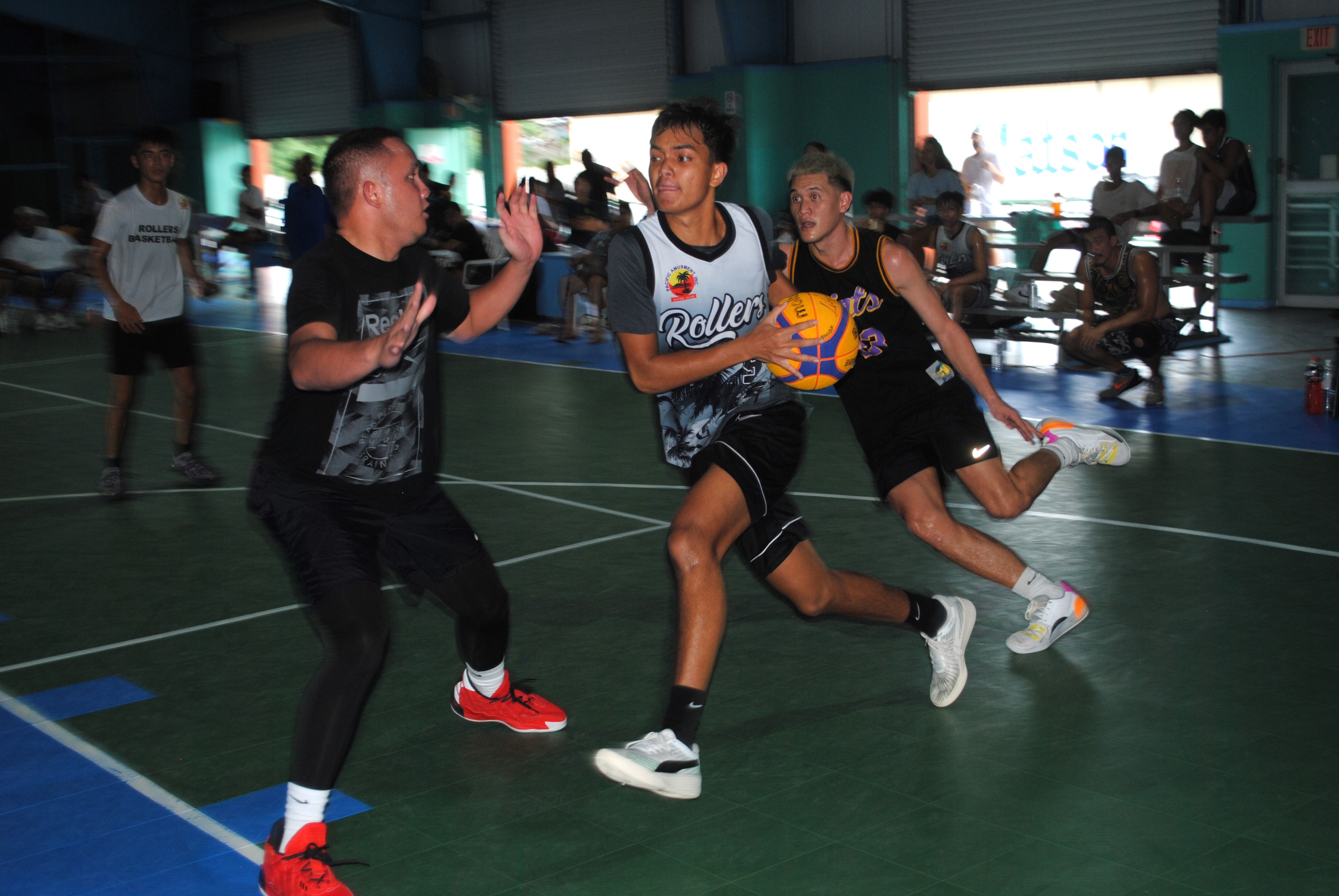 Chioni Dela Cruz protects the ball as he drives toward the rim. 
