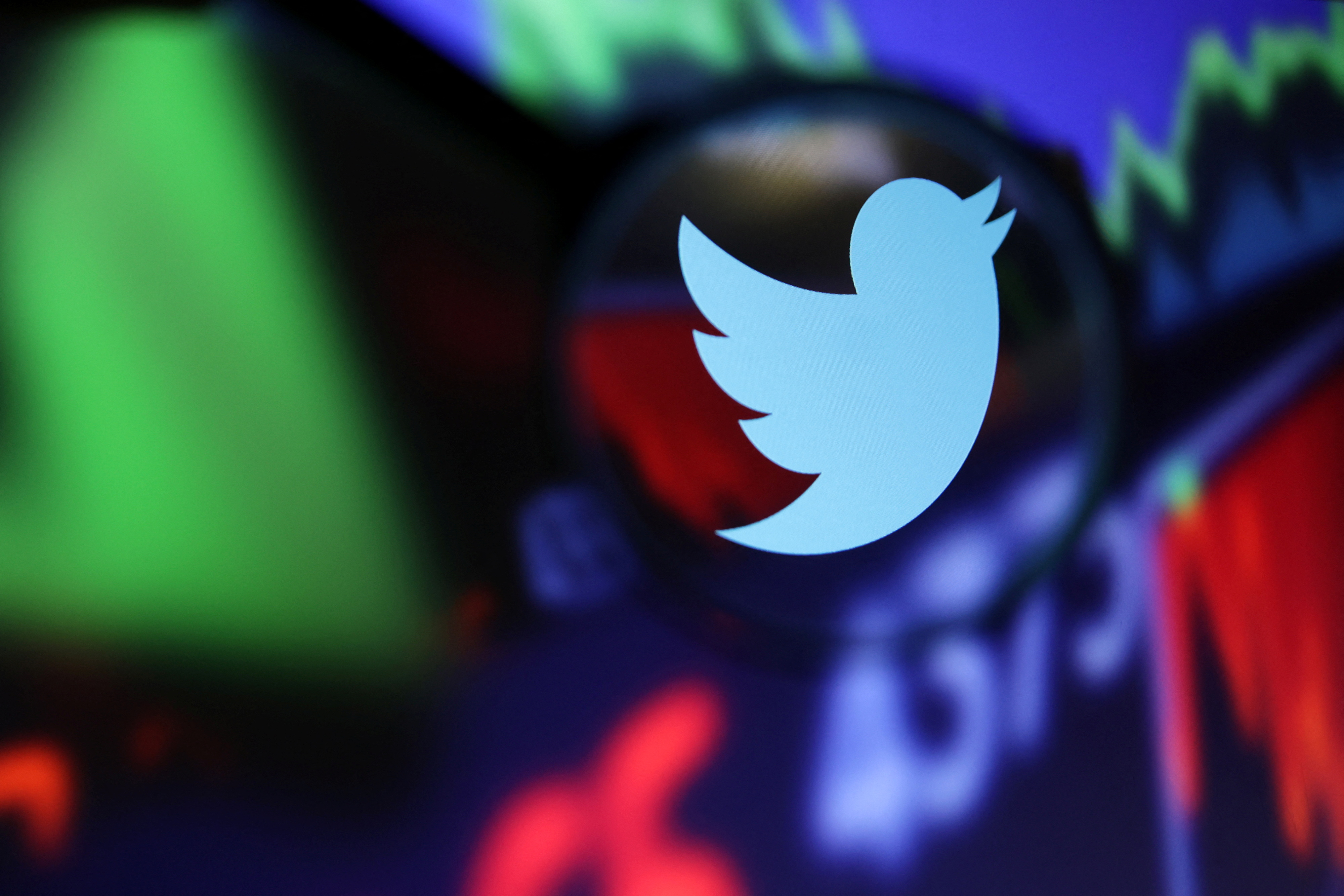 Twitter logo and stock graph are seen through a magnifier displayed in this illustration taken Sept. 4, 2022.