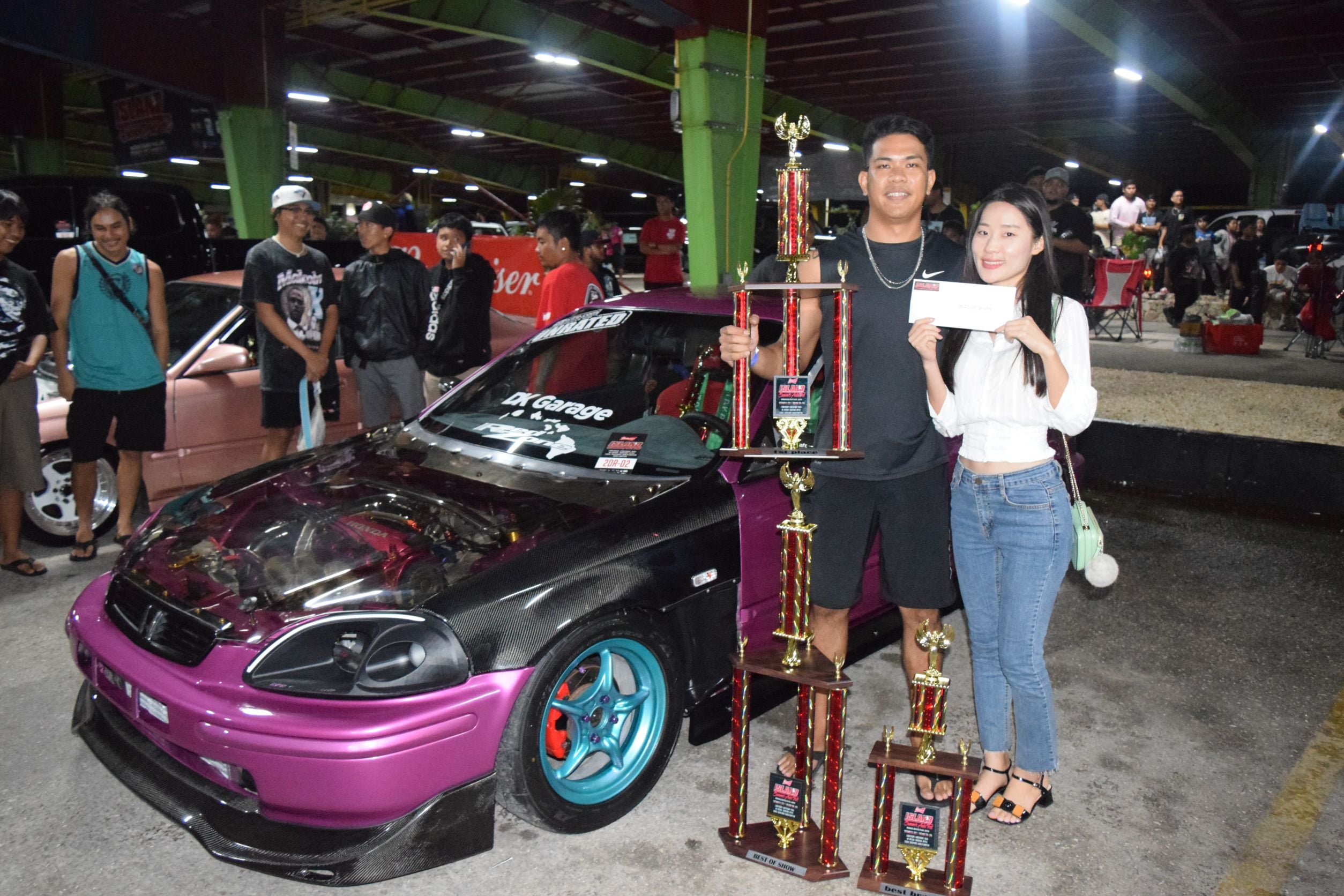 Mark Caacbay and his girlfriend pose with his customized 1997 Honda Civic DX after winning the 2022 Island Summer Auto Fest at the Marianas Business Plaza on Saturday.