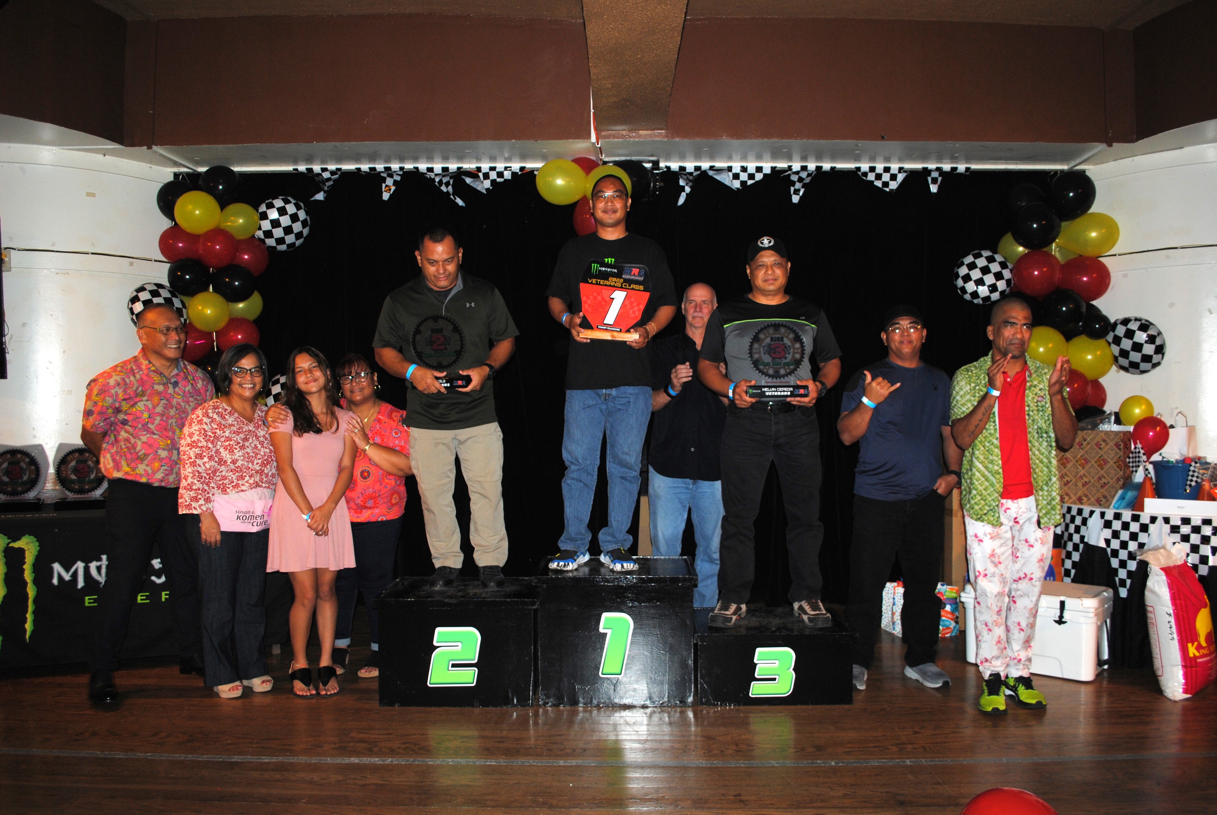 Champi Villacanes, center, holds the red plate trophy as he poses for a photo with Dave Celis, Melvin Cepeda, other Veteran Class riders, family members and Marianas Racing Association officials during the awards ceremony for the 2022 Monster Energy Points Race Series on Saturday at PIC.