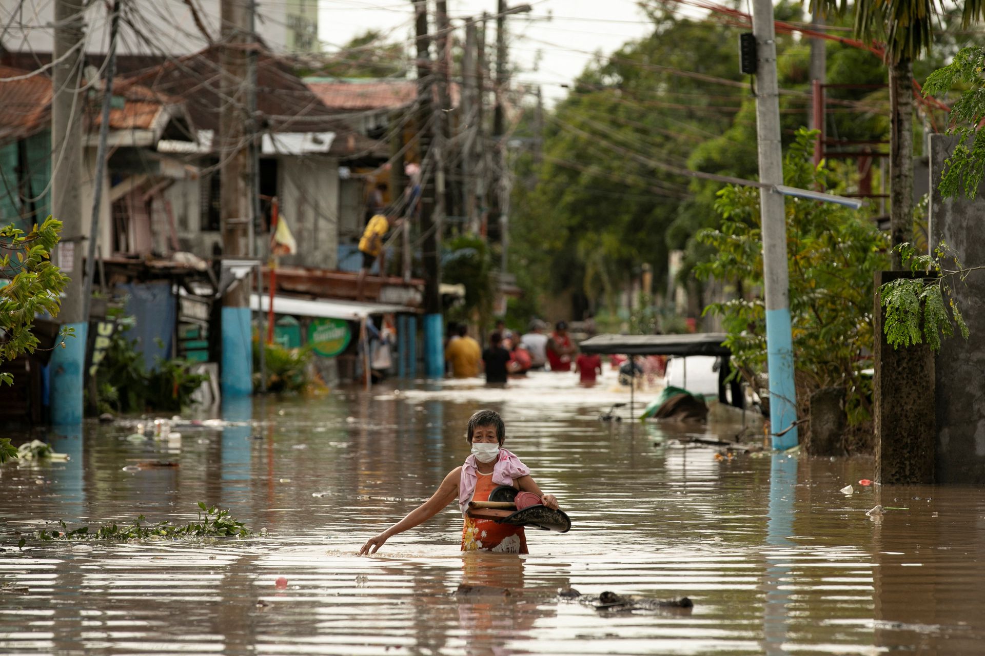 Residents wade through waist-deep flood waters after Super Typhoon Noru, in San Miguel, Bulacan province, north of Manila, the Philippines, Sept. 26, 2022.