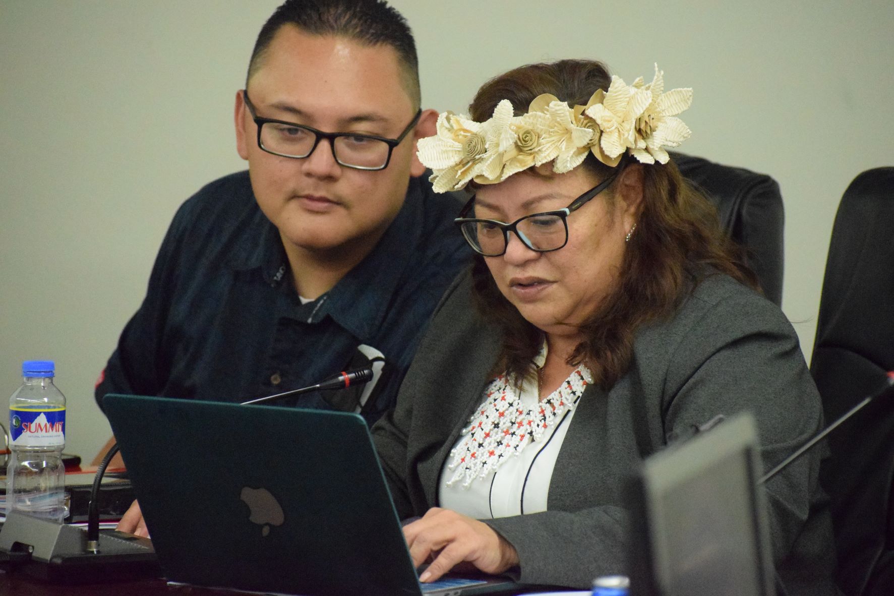 Reps. Celina Babauta, right, and Donald Manglona read a document on her laptop during a House session earlier this year.