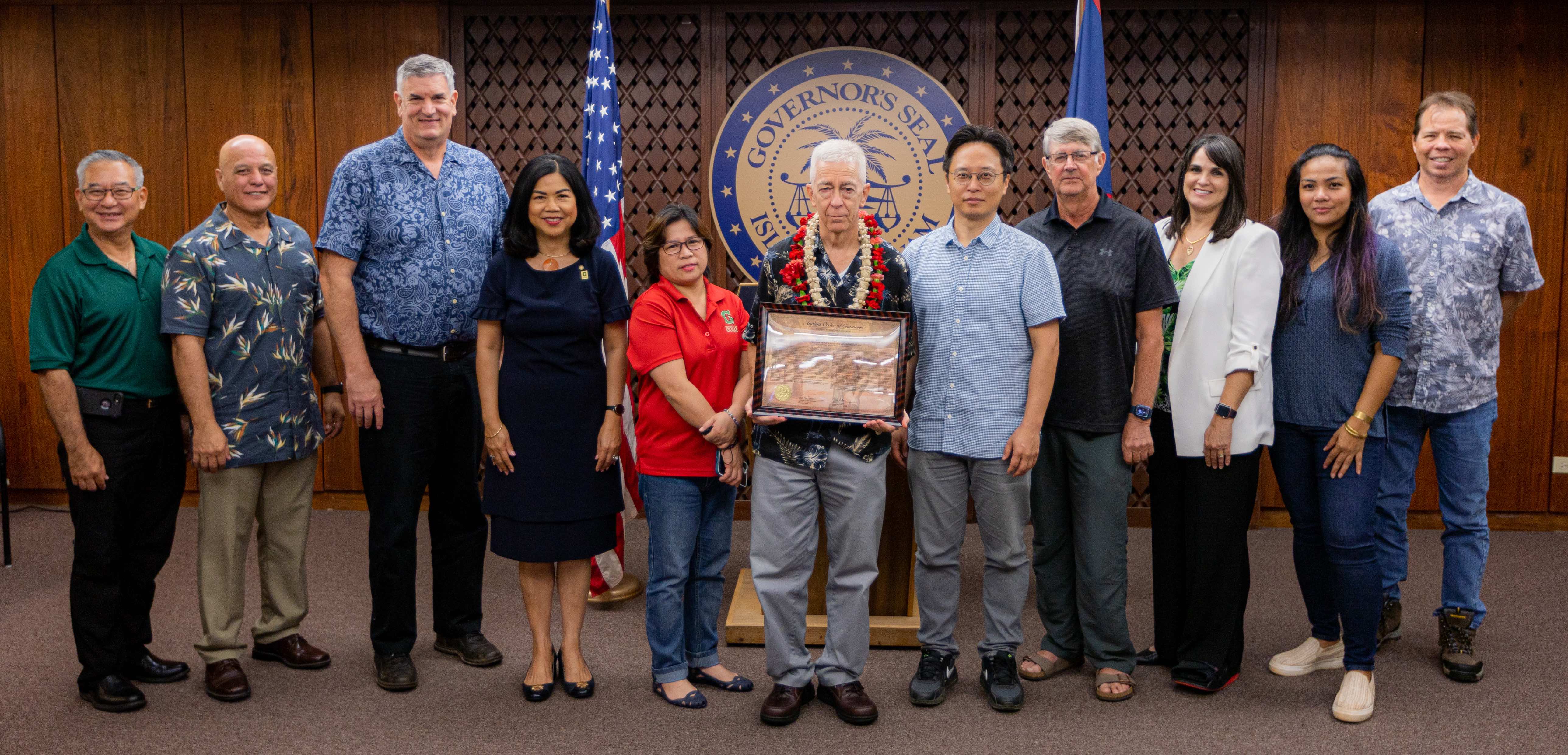 Colleagues and peers from within the University of Guam community join John W. Jenson, center, director and chief geologist of the Water and Environmental Research Institute of the Western Pacific, as he receives the Ancient Order of the Chamorri Award on Sept. 26 at the Ricardo J. Bordallo Governor’s Complex in Adelup.   