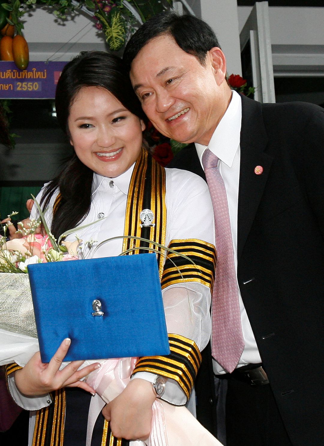 Former Thai Prime Minister Thaksin Shinawatra, who was deposed in a bloodless 2006 coup, poses with his daughter Paetongtarn during her graduation day at a Bangkok university on July 10, 2008.