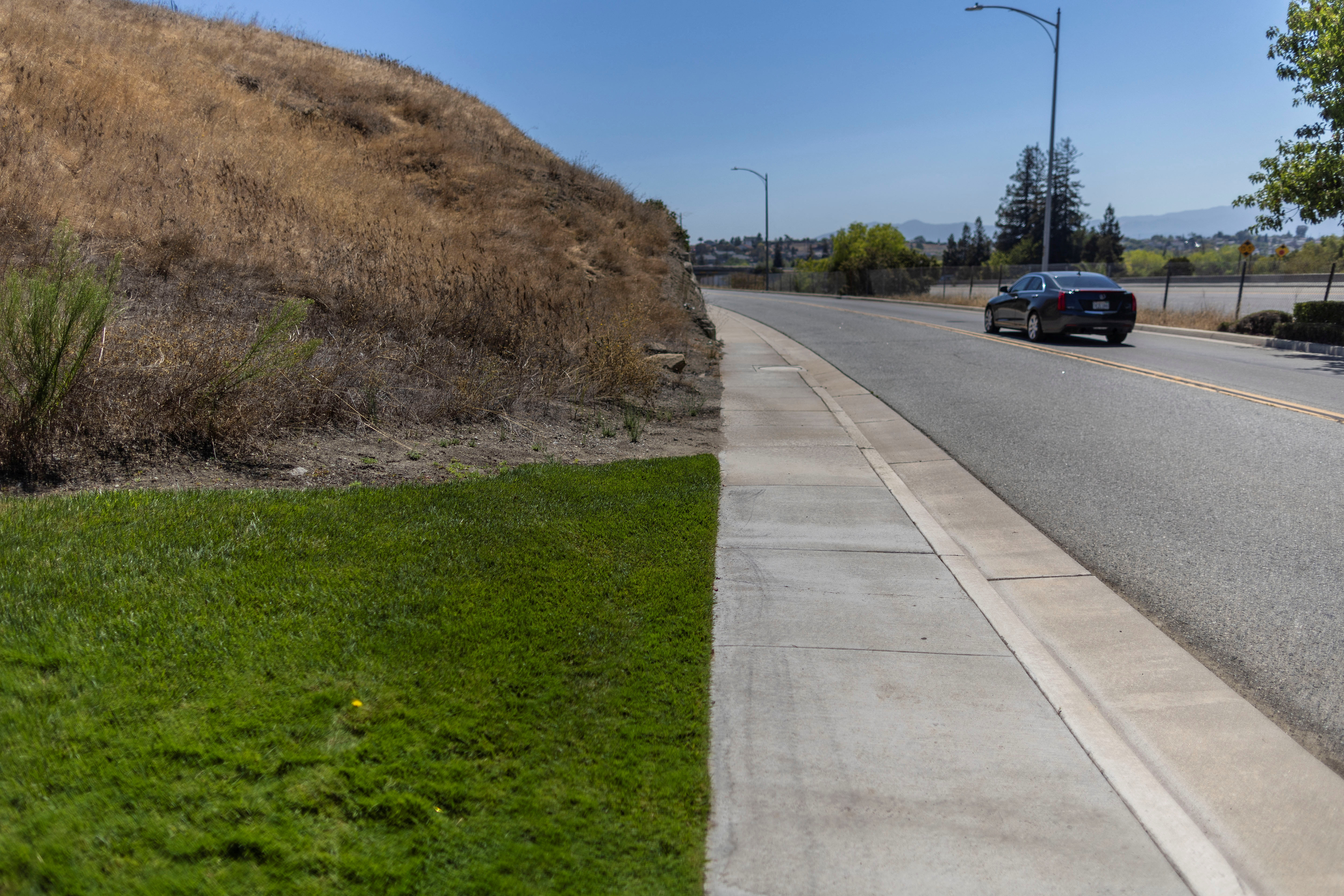 Recently watered grass is seen next to a dry-up area while extreme weather conditions including record-breaking heat waves are the latest sign of climate change in the western United States, where wildfires and severe drought have emerged as a growing threat, near San Jose, California, Aug. 15, 2022.