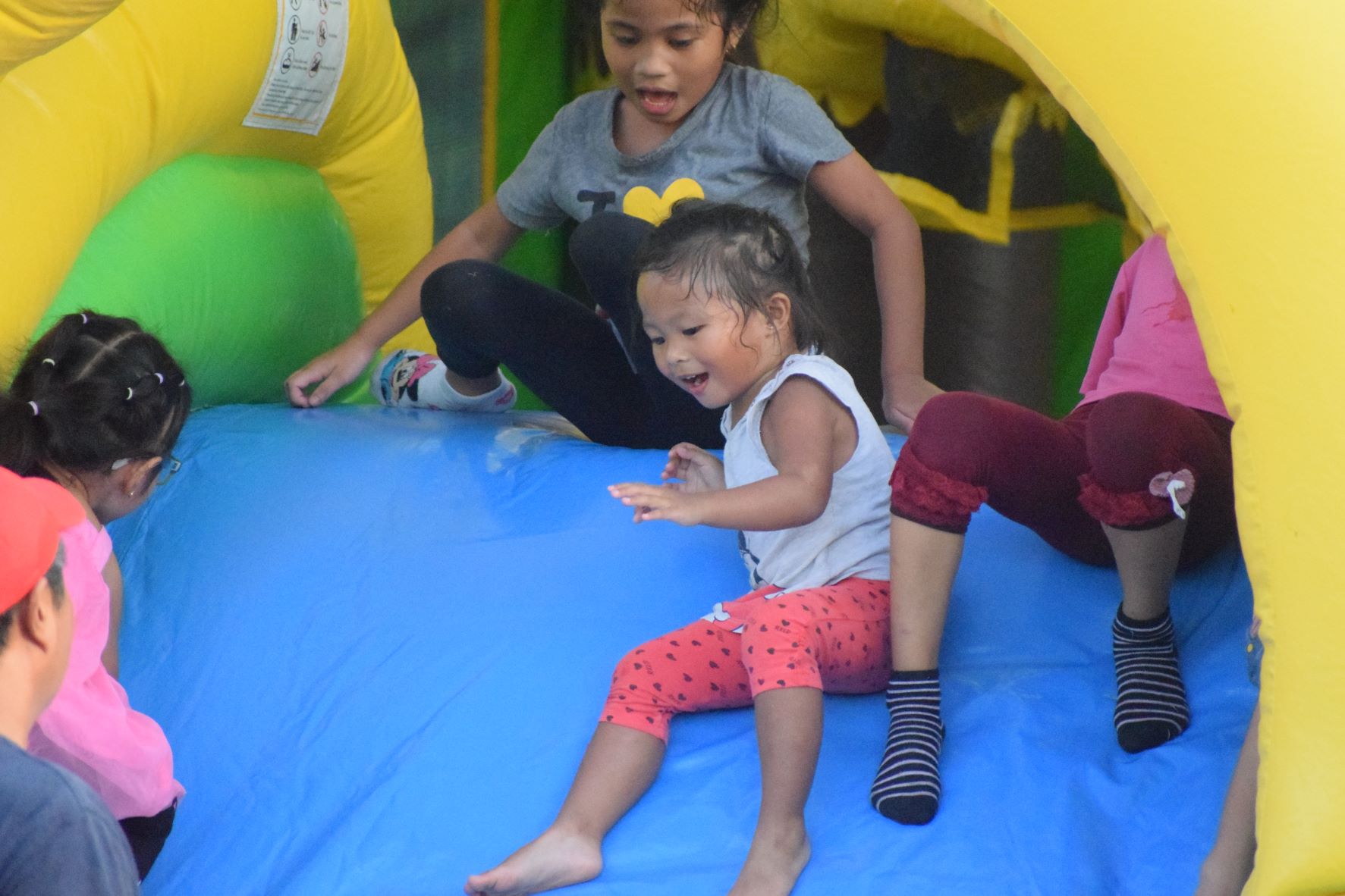 Children enjoy the slide at a bouncy castle during Fiesta Friday at the NMI Museum grounds on Friday.