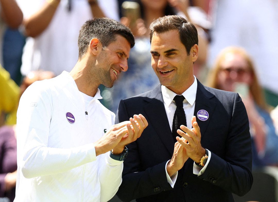 Serbia's Novak Djokovic and Switzerland's Roger Federer exchange pleasantries during center court centenary celebrations at the All England Lawn Tennis and Croquet Club in London, Britain on July 3, 2022.