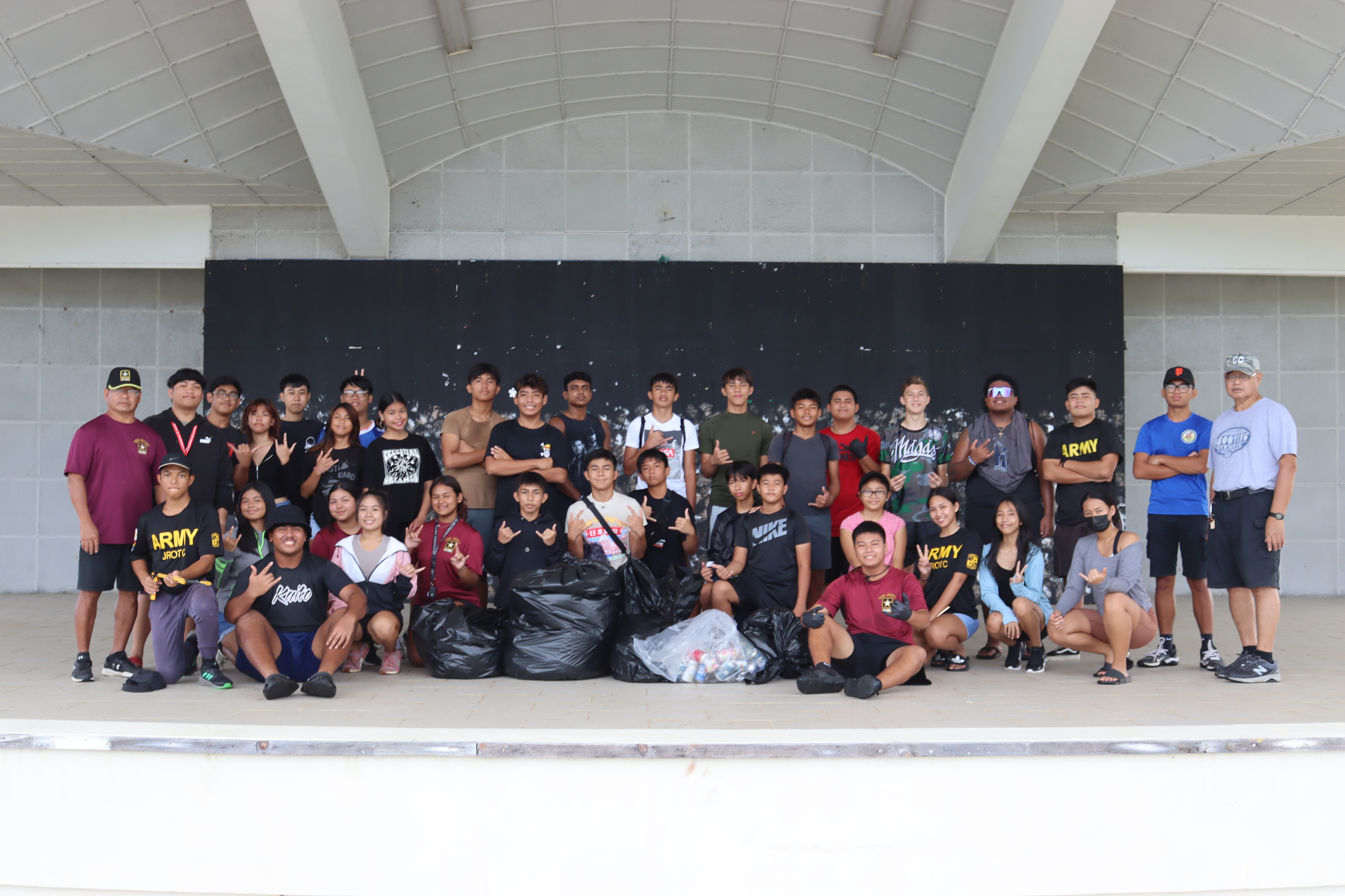 Tinian JROTC Stallion Battalion cadets pose with their bags of collected trash.