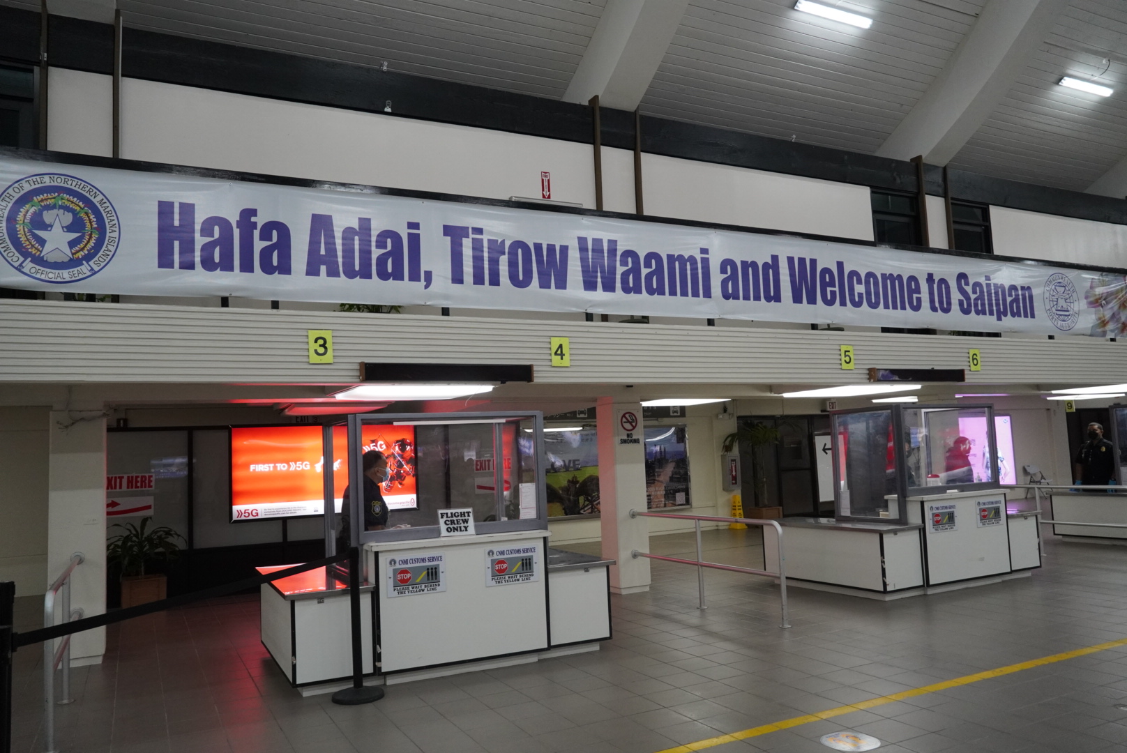 The "Hafa Adai, Tirow Waami, and Welcome to Saipan" banner adorns the Francisco C. Ada/Saipan International Airport arrival terminal, welcoming visitors and returning residents.