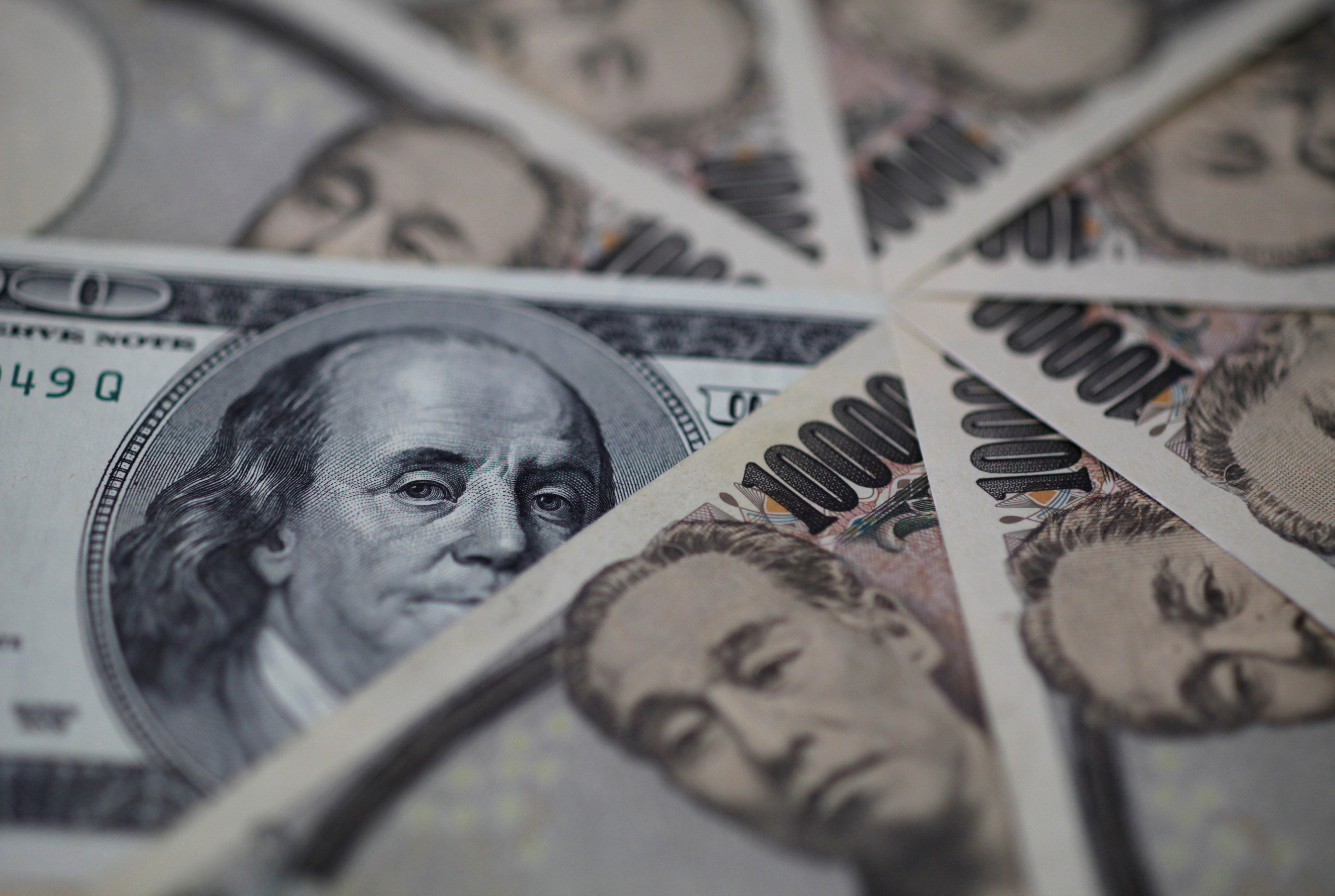 U.S. hundred dollar bill and Japanese 10,000 yen notes are seen in this photo illustration in Tokyo, Feb. 28, 2013.