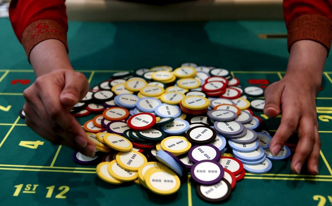 A casino dealer collects chips at a roulette table in Pasay City, Metro Manila, March 27, 2015.