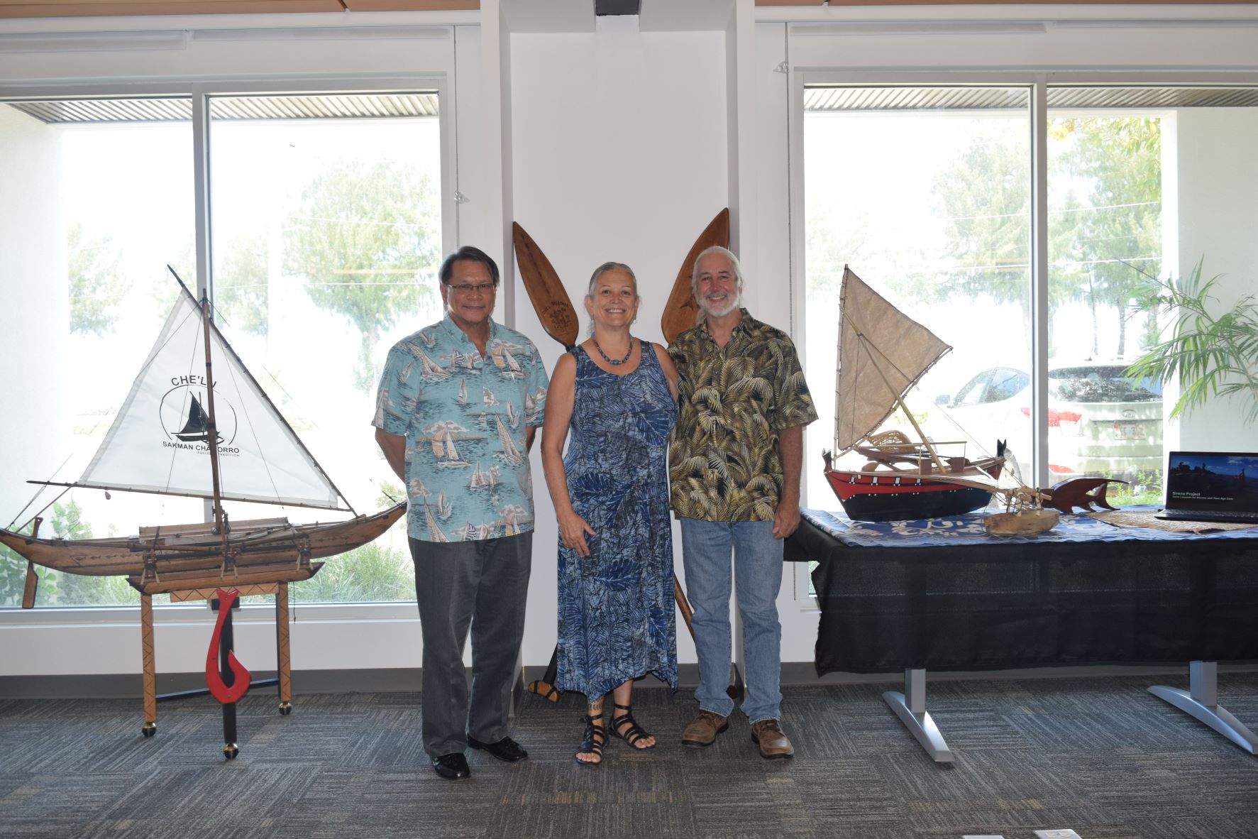 From left, Bank of Saipan President and CEO John Z. Arroyo, 500 Sails co-founder Emma Perez and executive director Pete Perez pose for a photo in the BoS exhibit room that features replicas of traditional canoes.