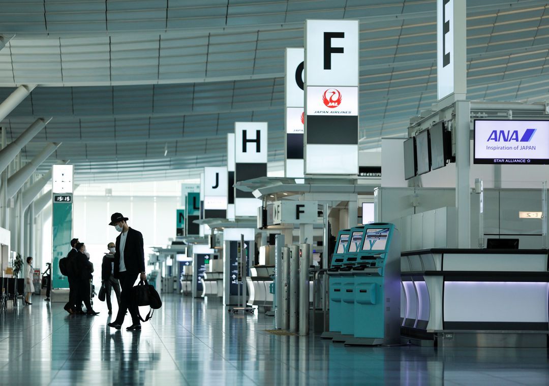 Passengers wearing protective face masks, amid the coronavirus disease pandemic, walk at the Haneda airport, in Tokyo, Japan on June 13, 2021.