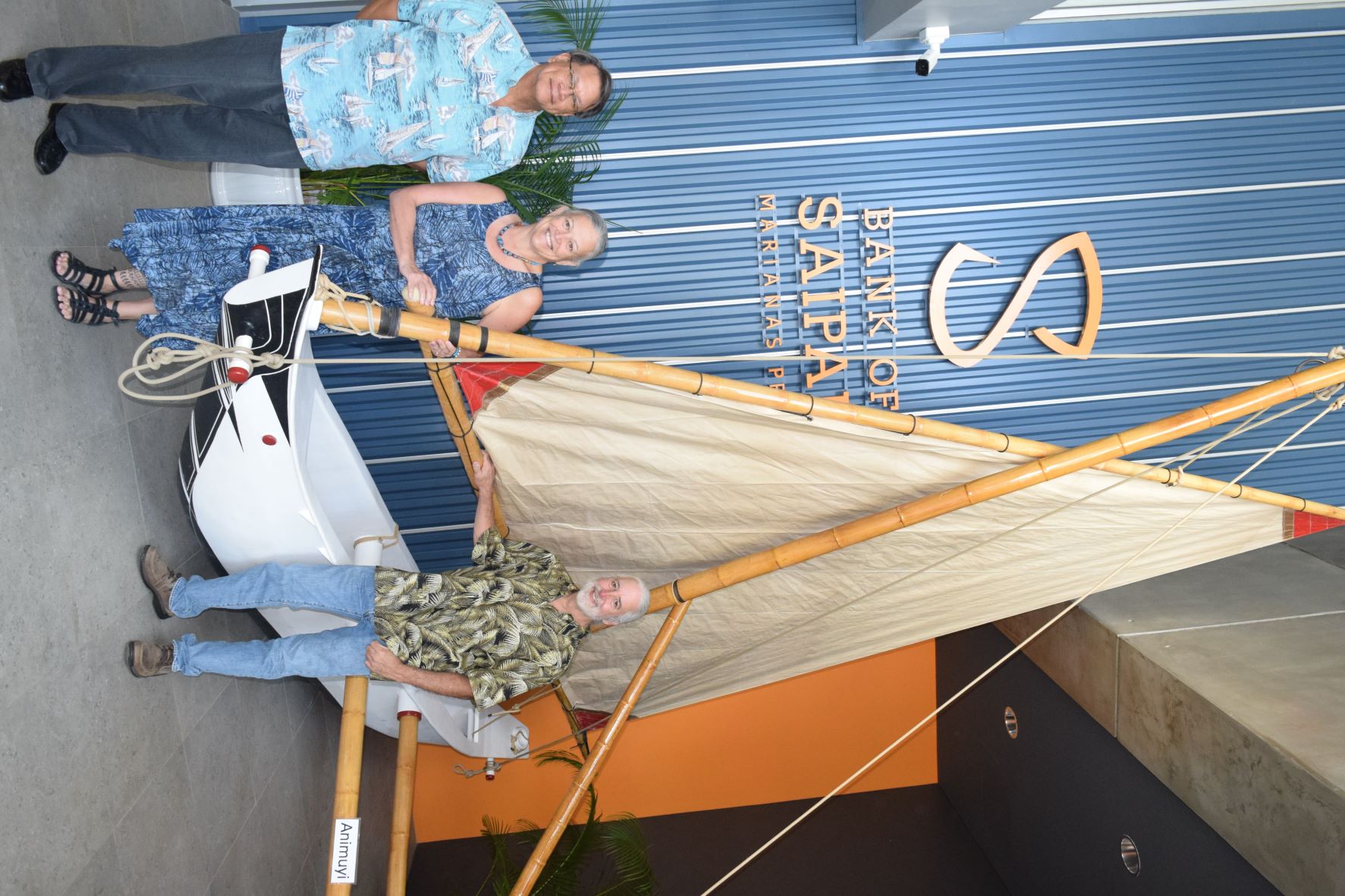 From left, Bank of Saipan President and CEO John Z. Arroyo, 500 Sails co-founder Emma Perez and executive director Pete Perez stand next to Animuyi now on display in the BoS lobby in Chalan Laulau.