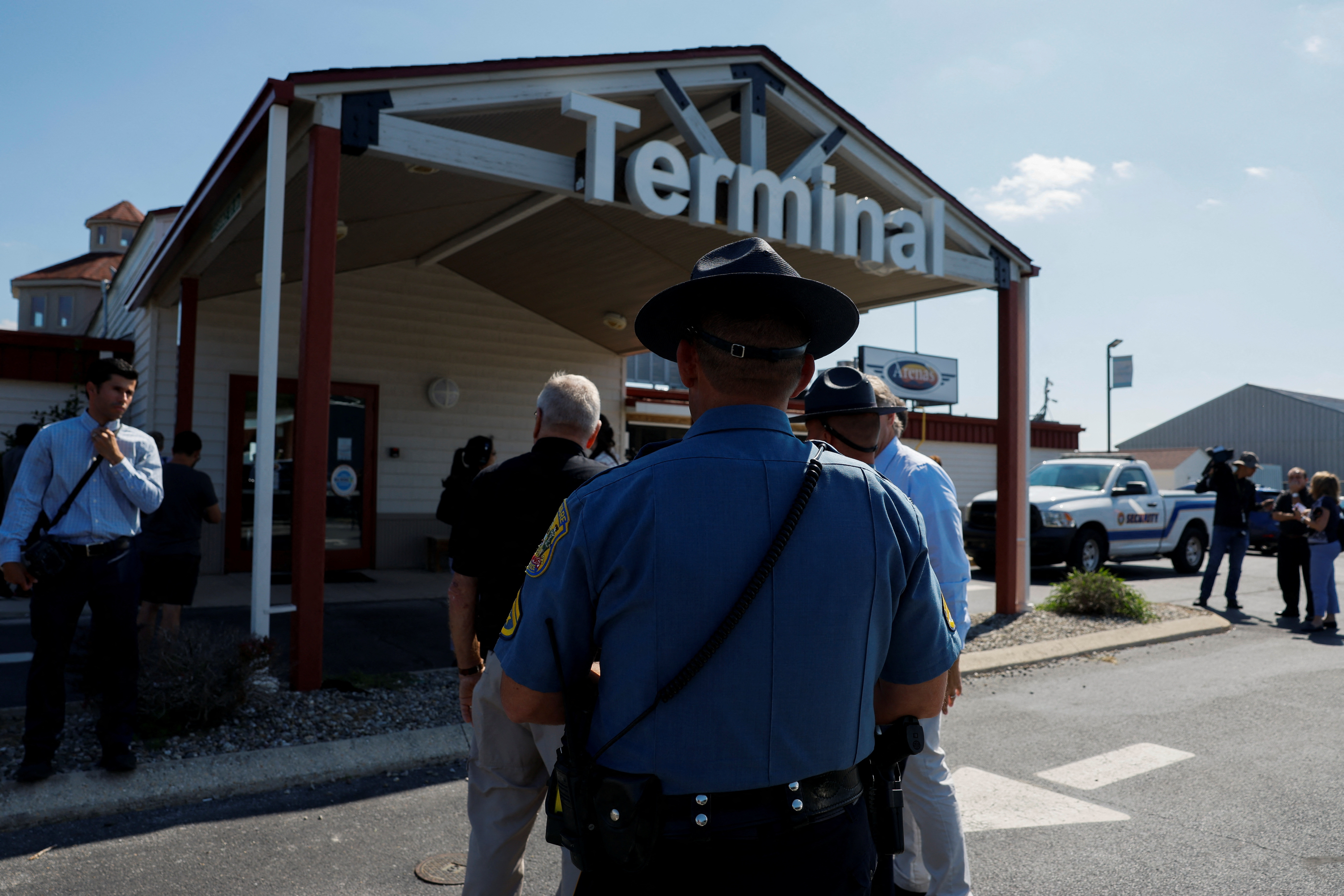 People gather outside ahead of the arrival of migrants who have been flown from Texas via Florida at Delaware Coastal Airport in Sussex County, Delaware, Sept. 20, 2022.
