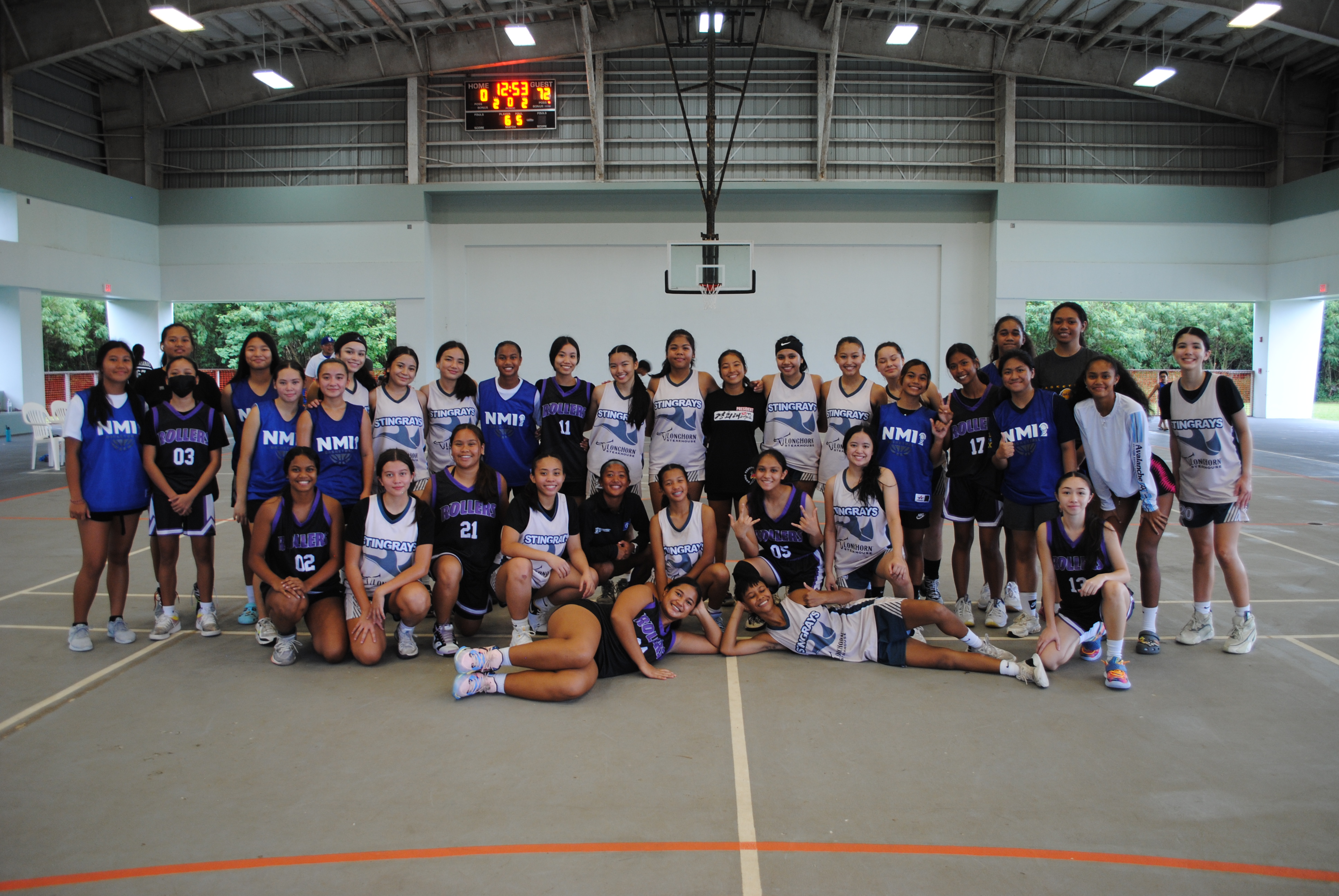 Guam and NMI basketball players pose for a photo after their inter-island friendship games on Saturday at the Koblerville gym.