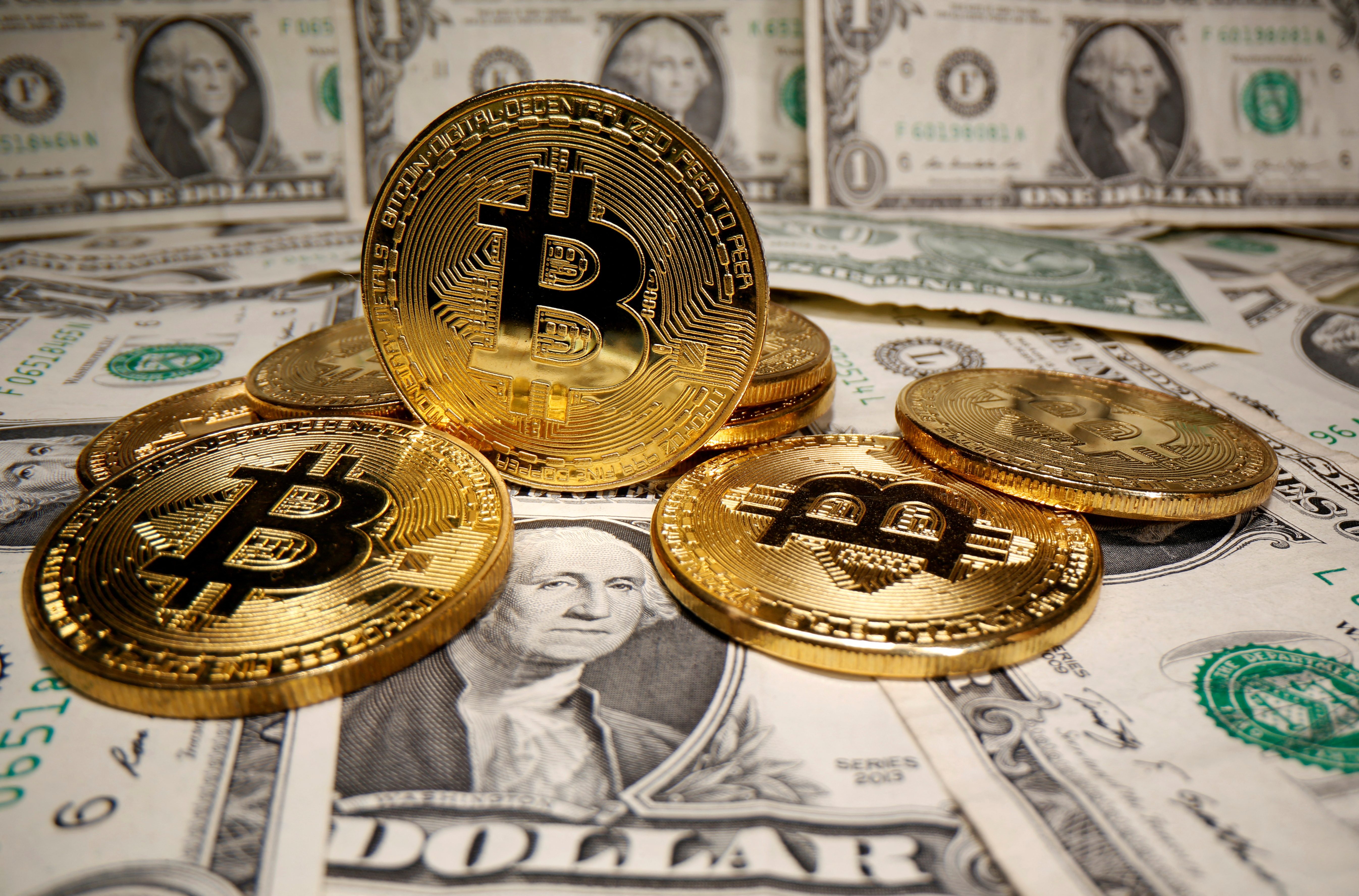 Representations of virtual currency Bitcoin are placed on U.S. dollar banknotes in this illustration taken May 26, 2020.