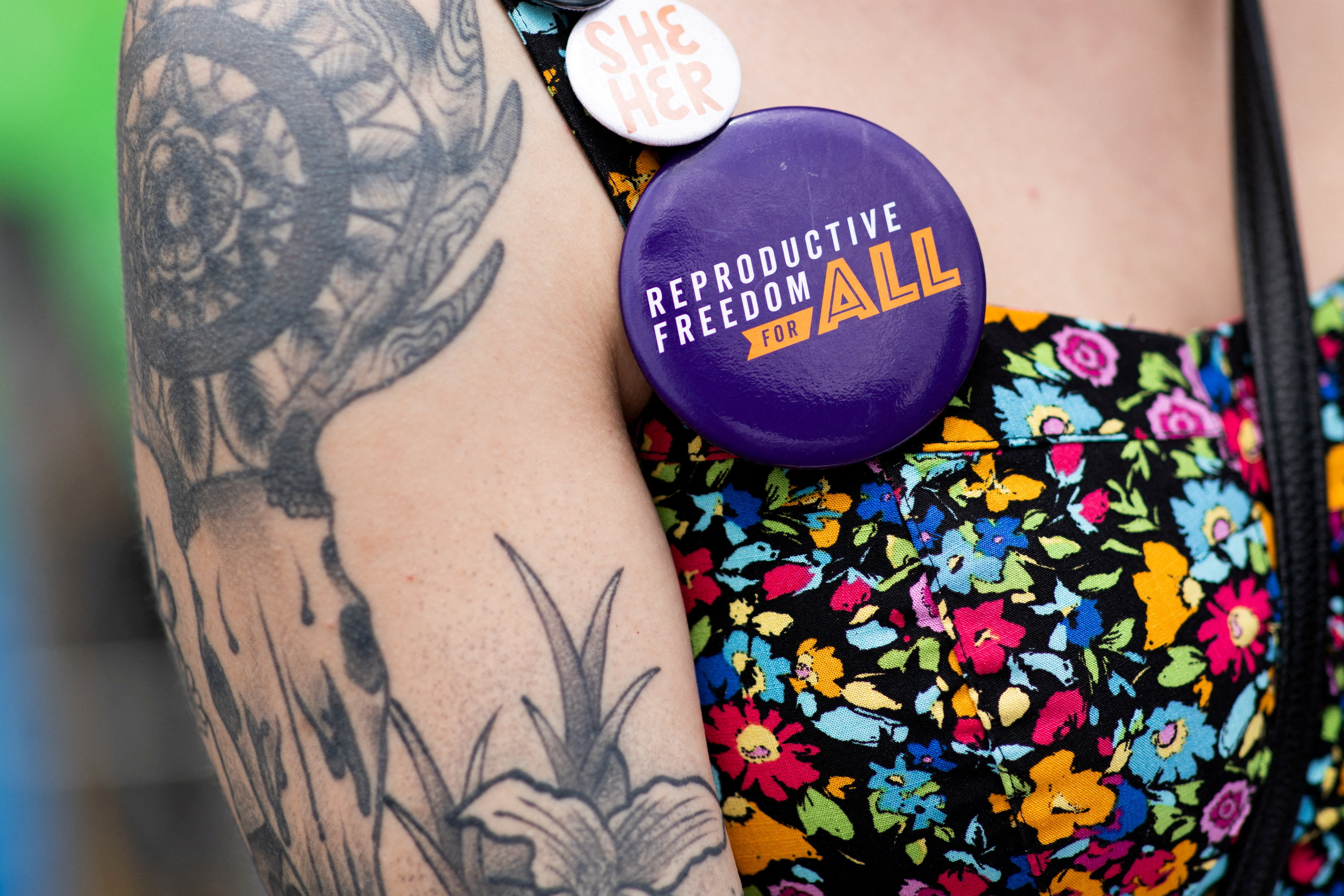 Volunteer Alex Cascio wears pins as she gathers signatures for a proposed abortion amendment at Ferndale Pride in Ferndale, Michigan, June 4, 2022.