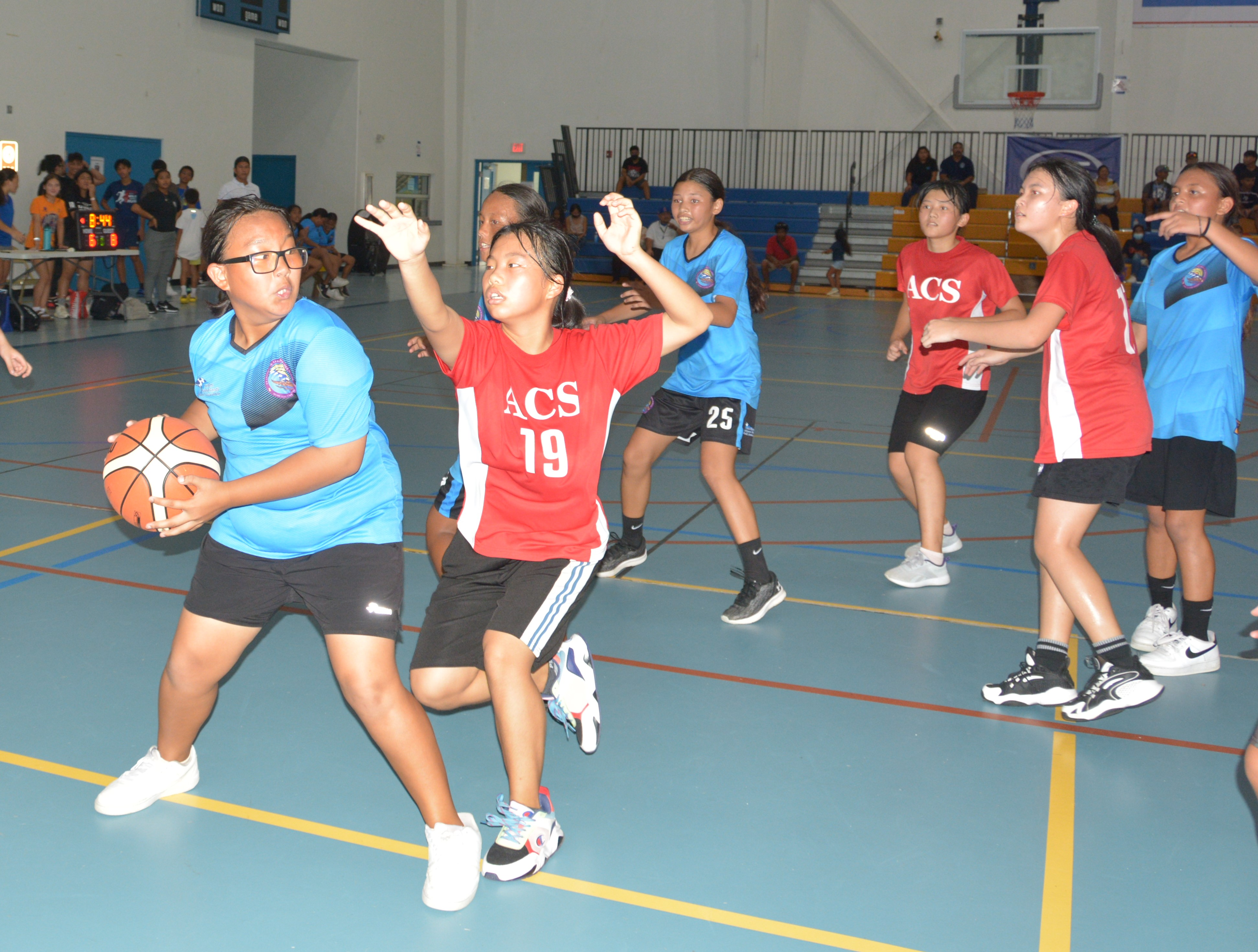 An FMS player protects the ball as an ACS defender closes in during an IT&E Interscholastic Basketball League game at the MHS gym.