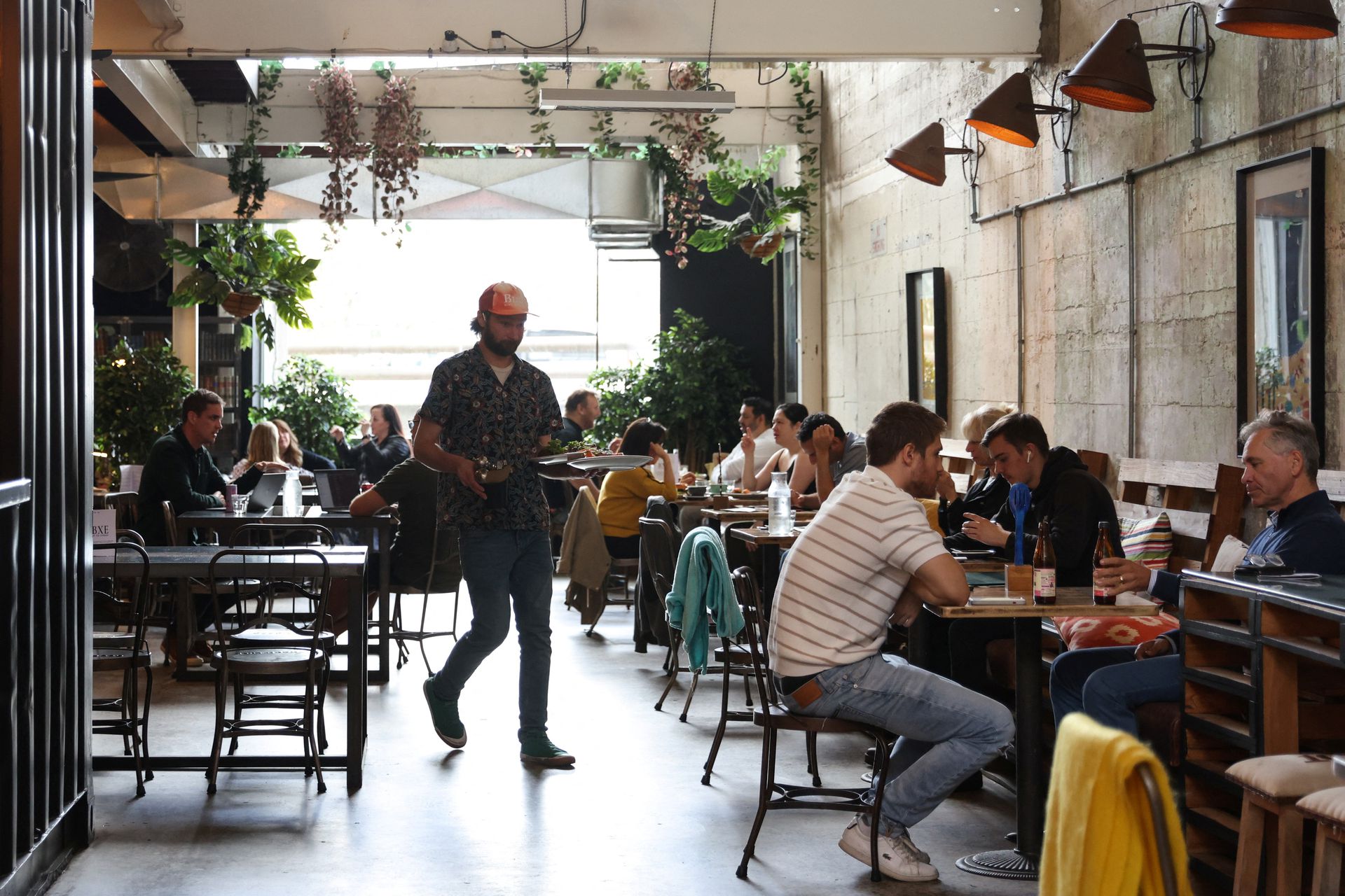 Café manager Rhyss Kearns serves customers at Bay Ten Espresso, a café that has struggled with filling staff job openings in recent months due to a worker shortage according to its owner, in Sydney, Australia, Aug. 31, 2022.