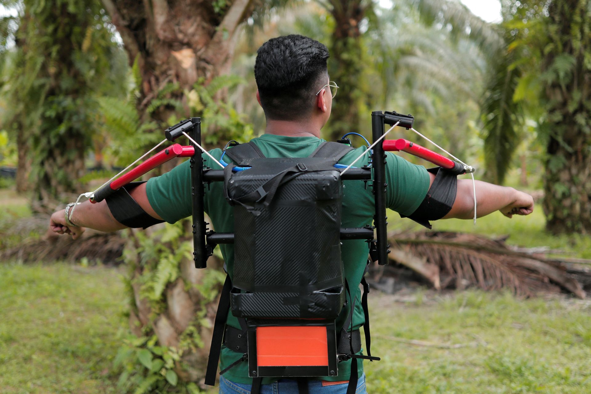 Research student Muhammad Haziq Ramli shows Terer, a robotic exoskeleton during a testing of the prototype at a palm oil plantation in Yong Peng, Johor, Malaysia, Sept. 8, 2022.