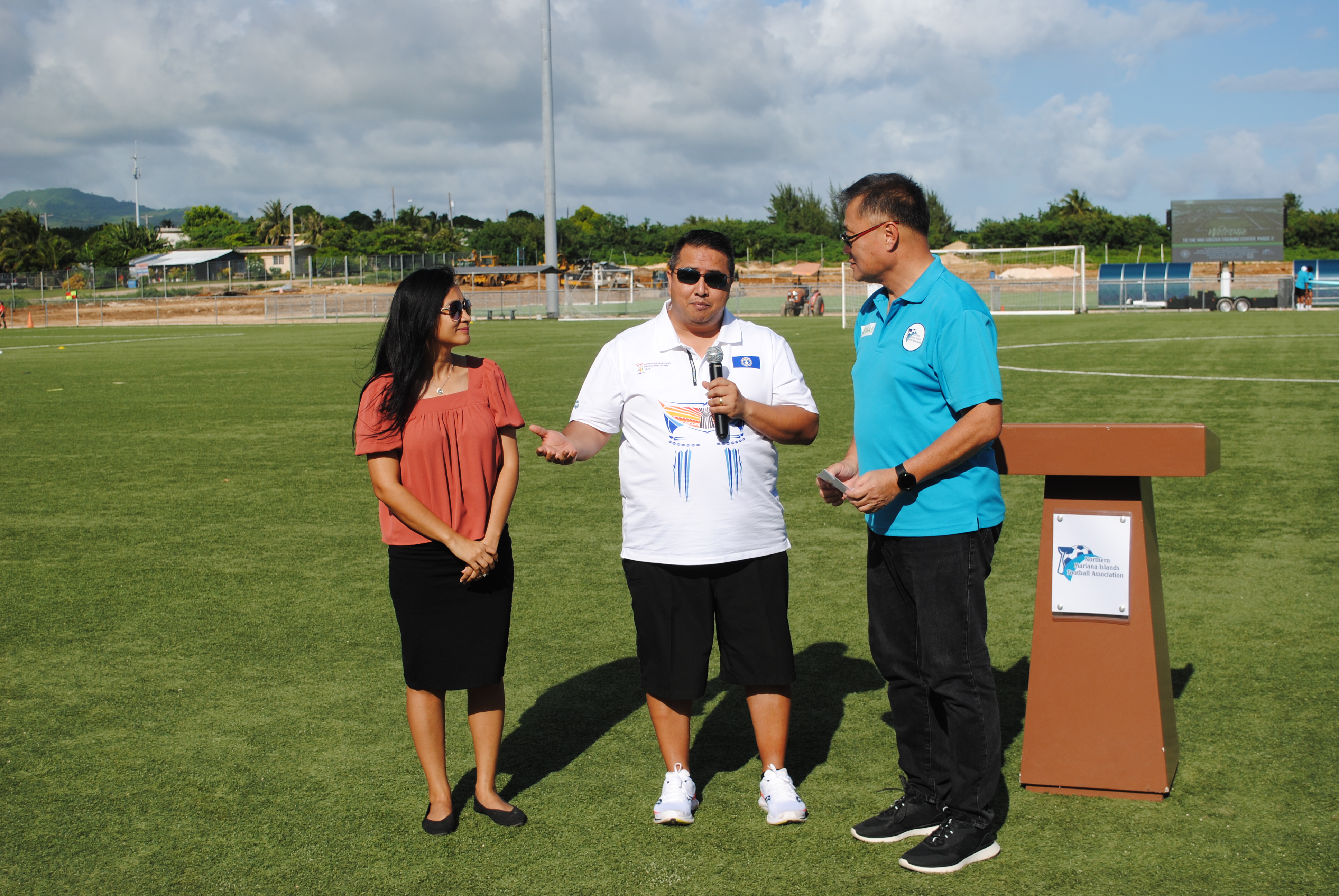 While first lady Diann T. Torres, left, and Northern Mariana Islands Football Association President Jerry Tan, right, look on, Gov. Ralph DLG Torres shares a few words before handing a check for $750,000 to the NMIFA during the inauguration of the NMI Soccer Training Center’s second regulation-size soccer pitch on Saturday.