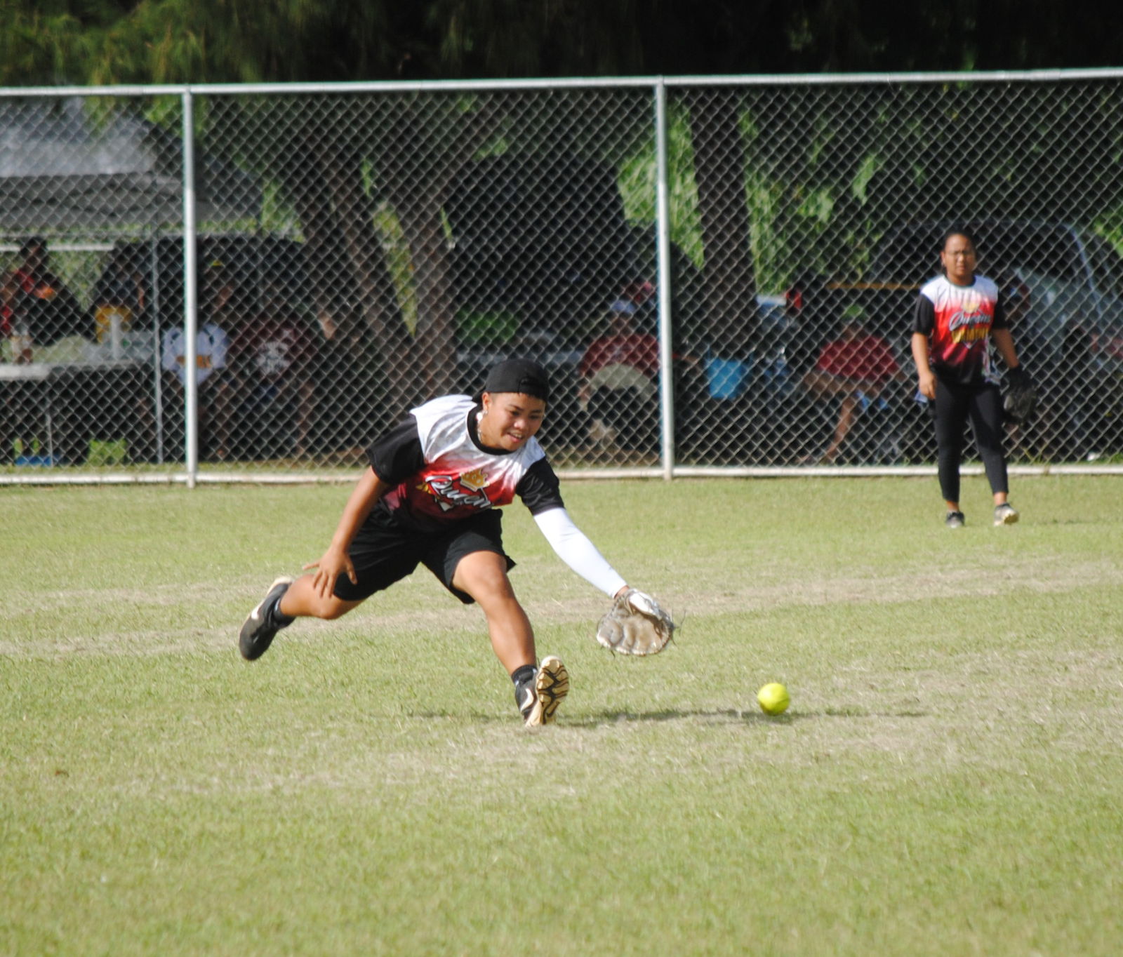 Queens of Diamonds' Kiana Aldan reaches for the grounder during a 2022 Budweiser Belau Amateur Softball League game at the Dandan baseball field.