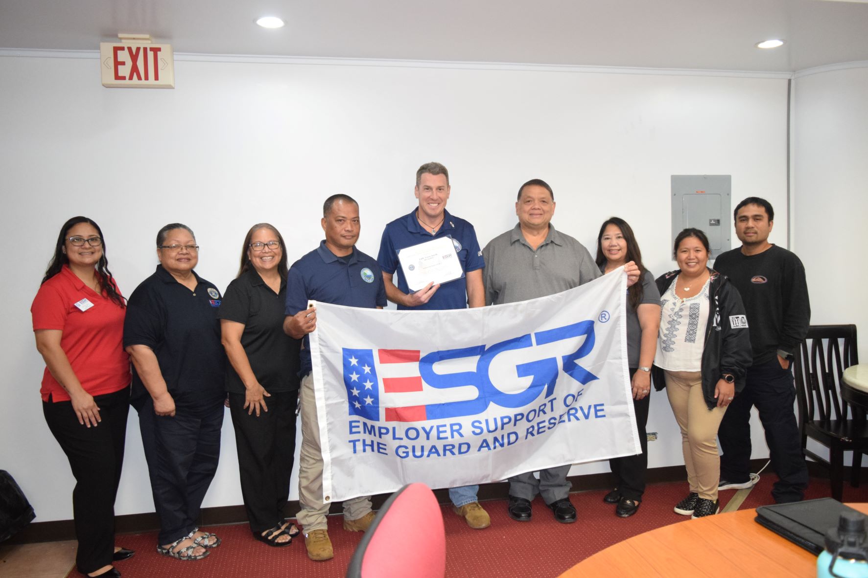 Bureau of Environmental and Coastal Quality Safe Drinking Water and Ground Water Management Program manager, Cmdr. Travis Spaeth, center, holds the Patriotic Employer Award as he poses for a photo with Employer Support of the Guard and Reserve Guam-CNMI Area Chair Rita A. Sablan, Ed.D., third left, Employer Outreach Coordinator Rose Igitol, second left, Environmental Specialist Aloysius Atalig, fourth left, BECQ Administrator Eli D. Cabrera, fourth right, ESGR Ombudsman Joann Aquino, third right,  ESGR volunteer Joshlyn Blas, left, and other BECQ staffers.