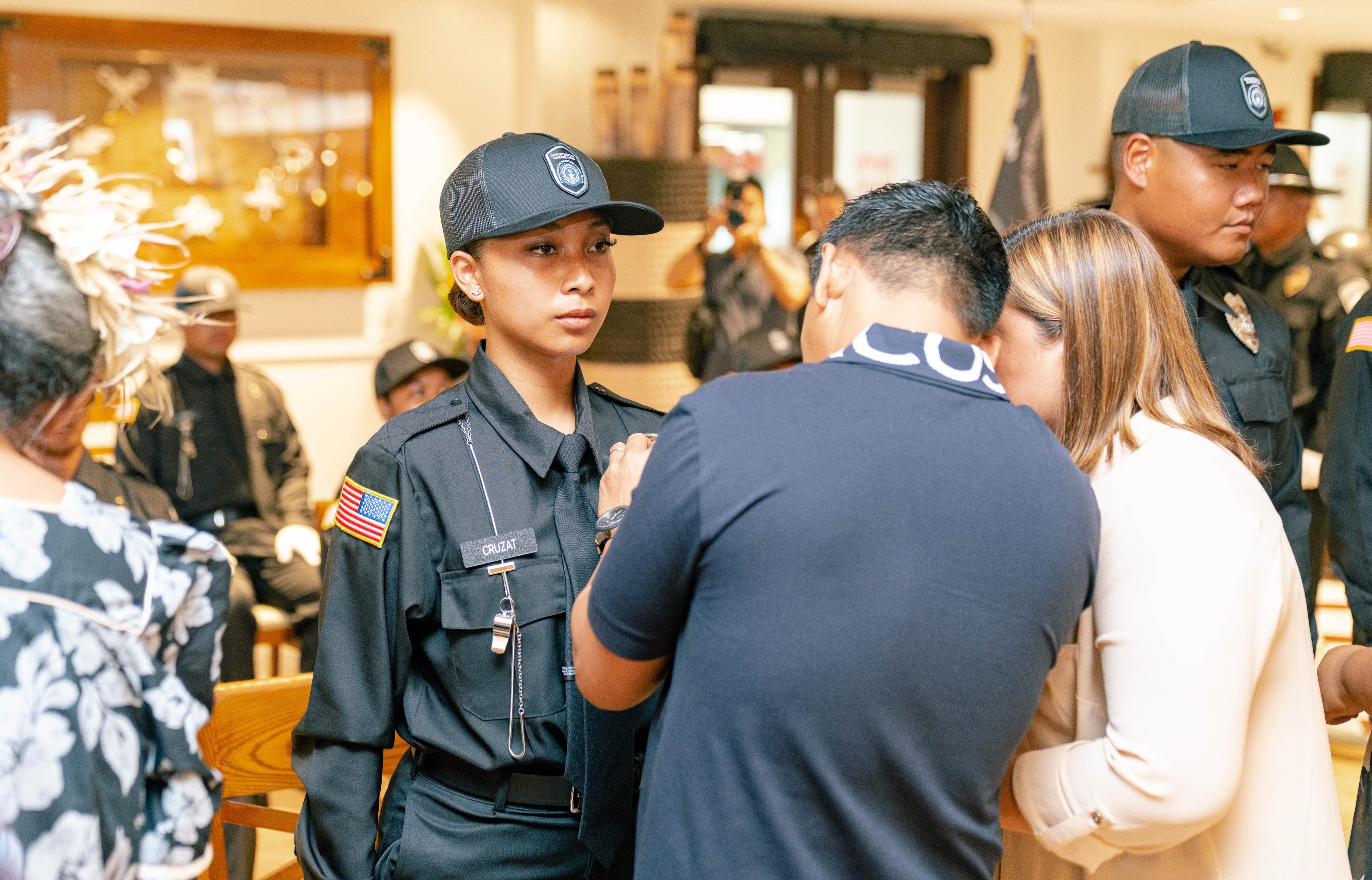 9th Cycle Corrections Academy salutatorian Daphne I. Cruzat’s father pins a badge on her uniform during the graduation ceremony on Thursday, Oct. 6, 2022 at the Pacific Islands Club.