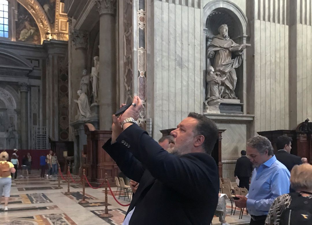 Actor Russell Crowe uses his smartphone inside St. Peter's Basilica after attending a special screening in the Vatican of the new film "The Greatest Beer Run Ever" for recruits of the Vatican's gendarmes and Swiss Guard, and for Marines guards from the U.S. Embassy in Rome, at the Vatican, Oct. 17, 2022.