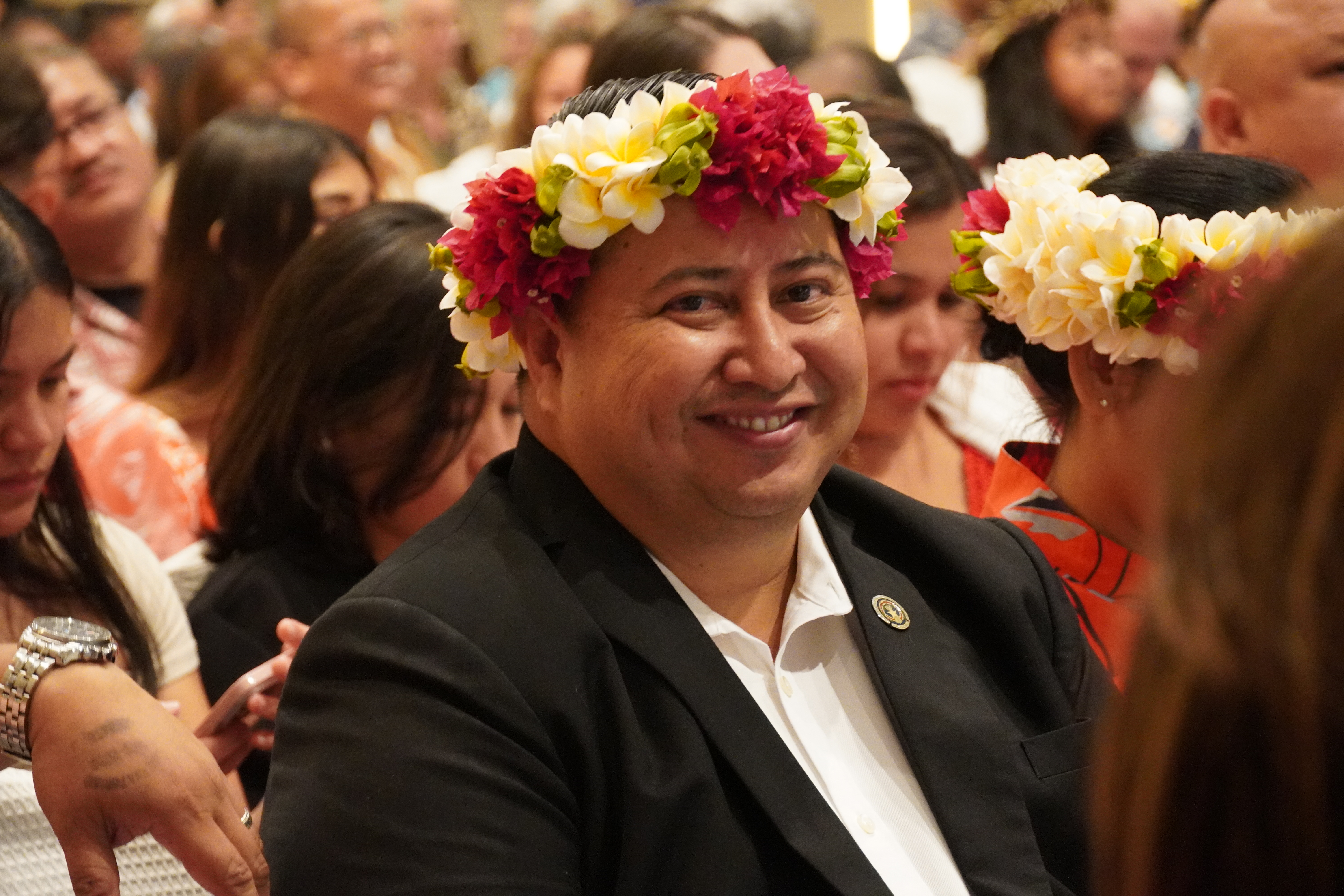 Republican Gov. Ralph DLG Torres smiles while seated, waiting for the debate to begin.
