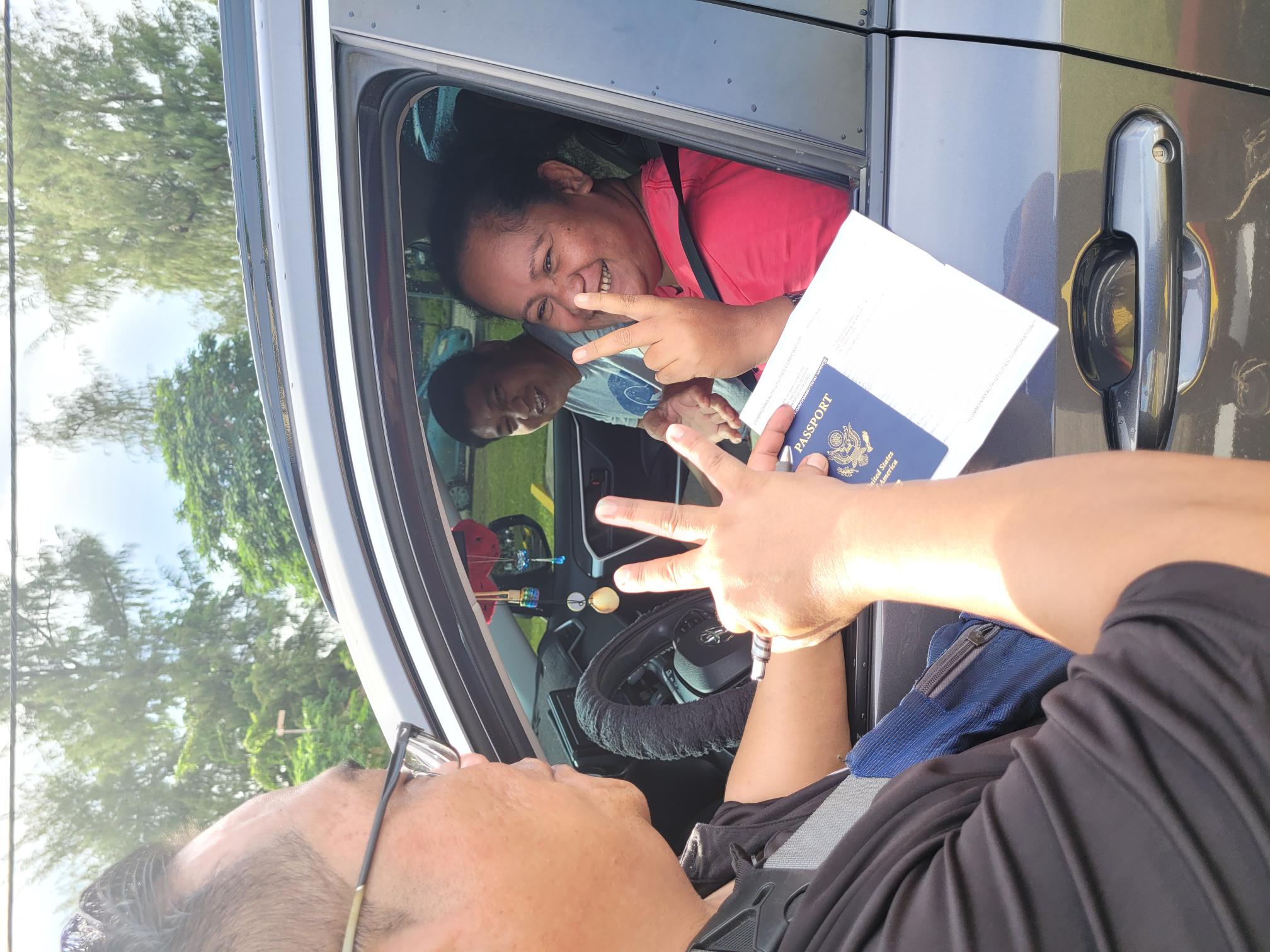 Husband and wife Rolly and Trinidad Pangilinan smile as a government staffer checks their documents during the electric fan drive-thru distribution at the multi-purpose center Wednesday afternoon.