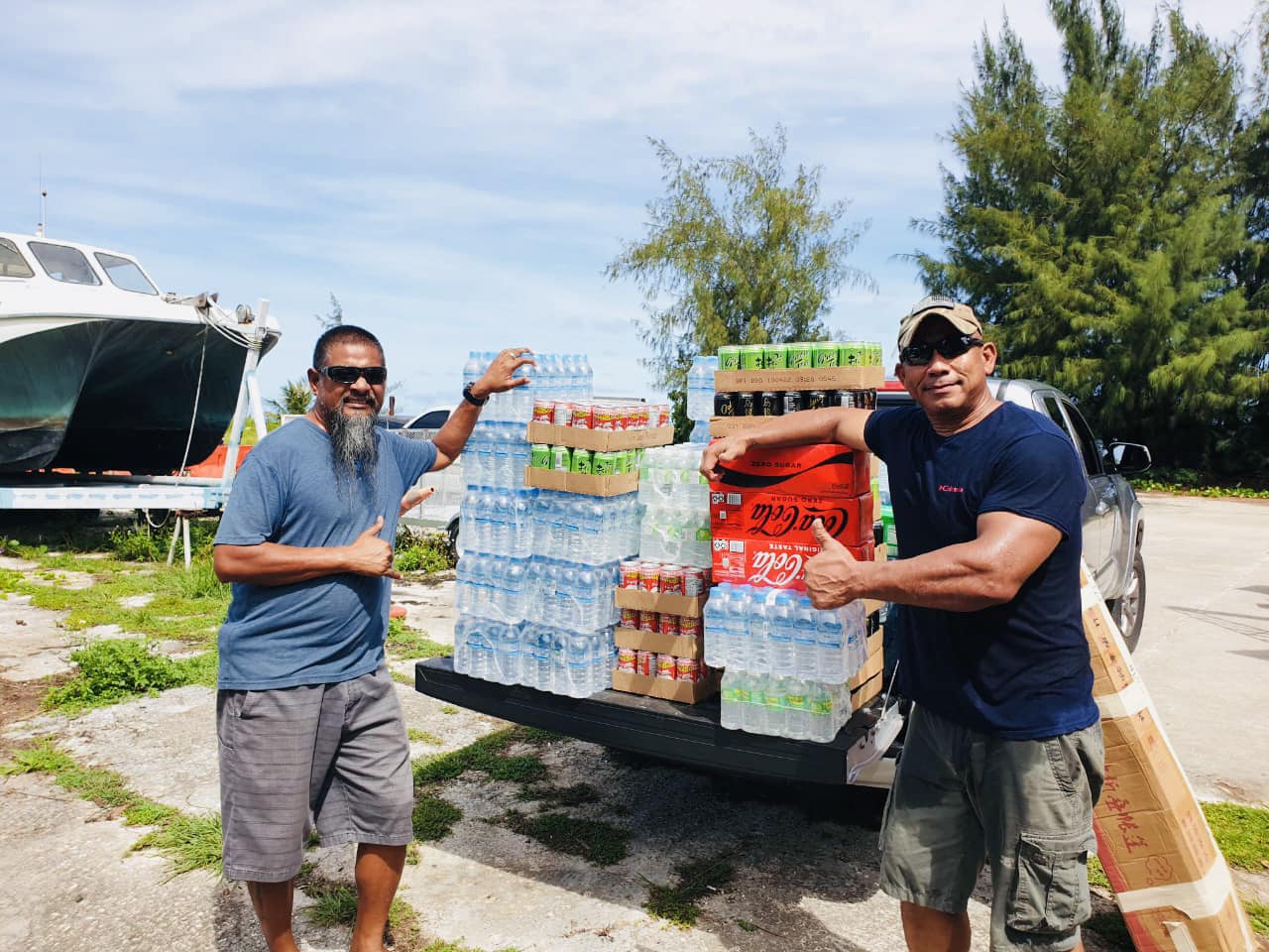 Rota House candidate Edward C. Barcinas and Marianas Blue Water owner Cecilio Raiukiulipiy stand next to the donated cases of bottled water and sodas for the San Francisco De Borja Parish Church fiesta on Rota set for Saturday, Oct. 8.