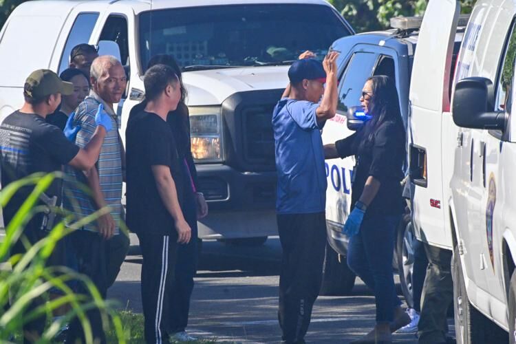 Police officers and customs agents frisk Chinese nationals who were apprehended Thursday near the Pago Bay bridge and are suspected of illegal entry into Guam. A total of nine people were arrested, authorities said.