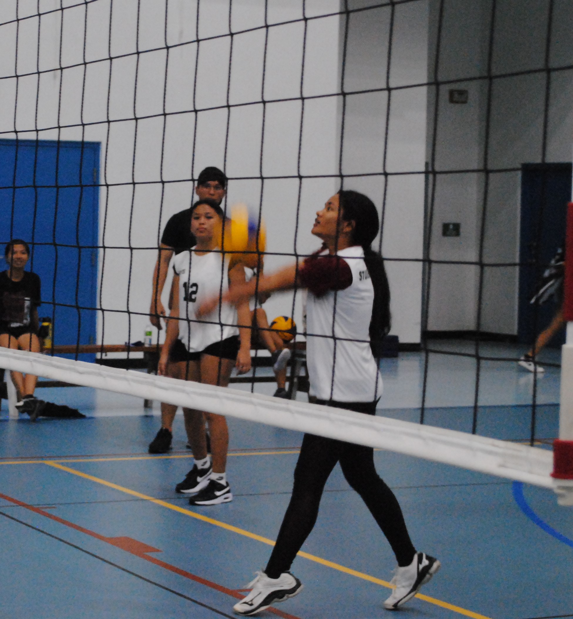 An MHS JV player extends for the bump return during an NMIVA-PSS Girls High School Volleyball game at the MHS gym.