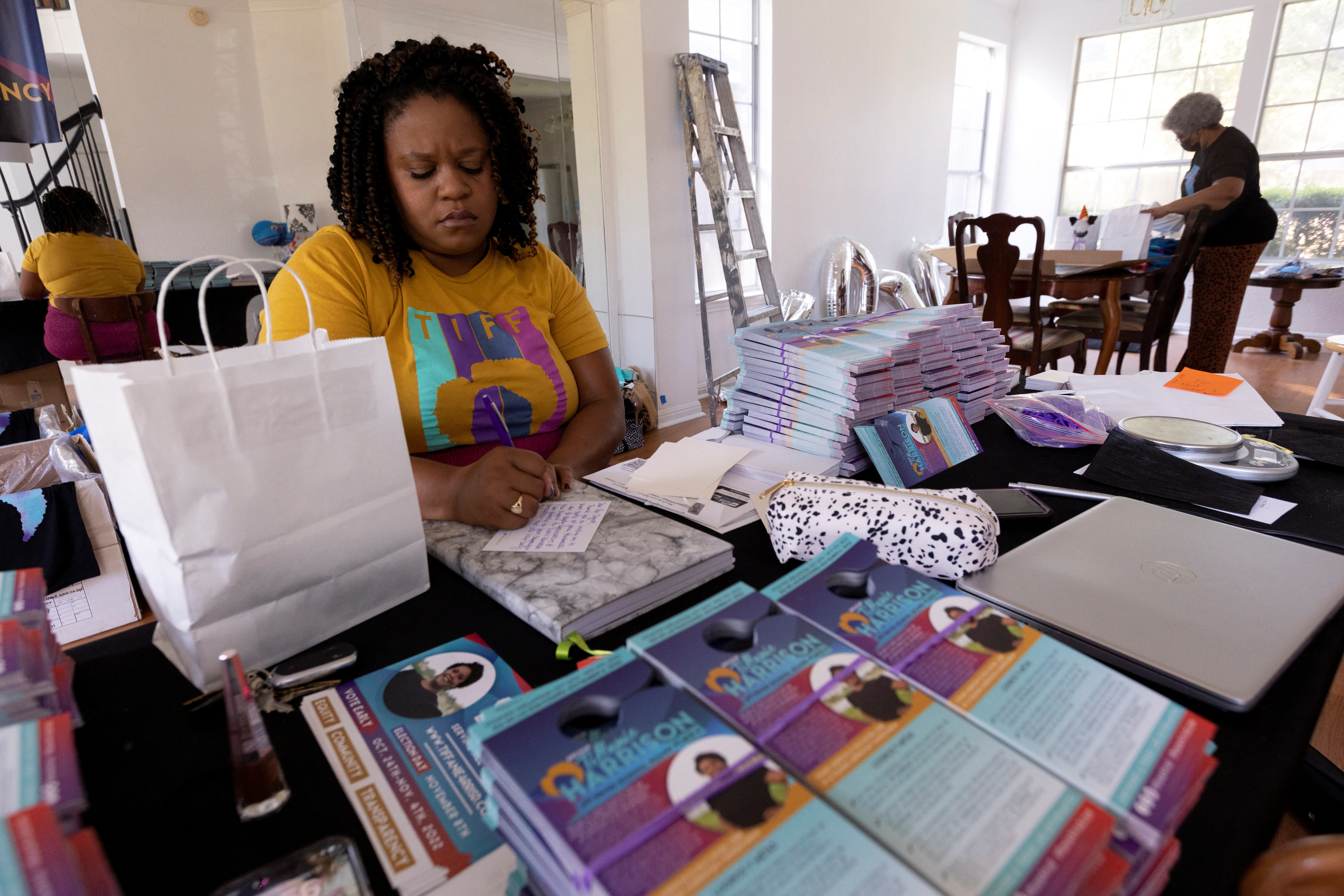 Incumbent school board candidate Tiffanie Harrison writes thank you notes at her mother's home in Round Rock, near Austin, Texas, Oct. 12, 2022.