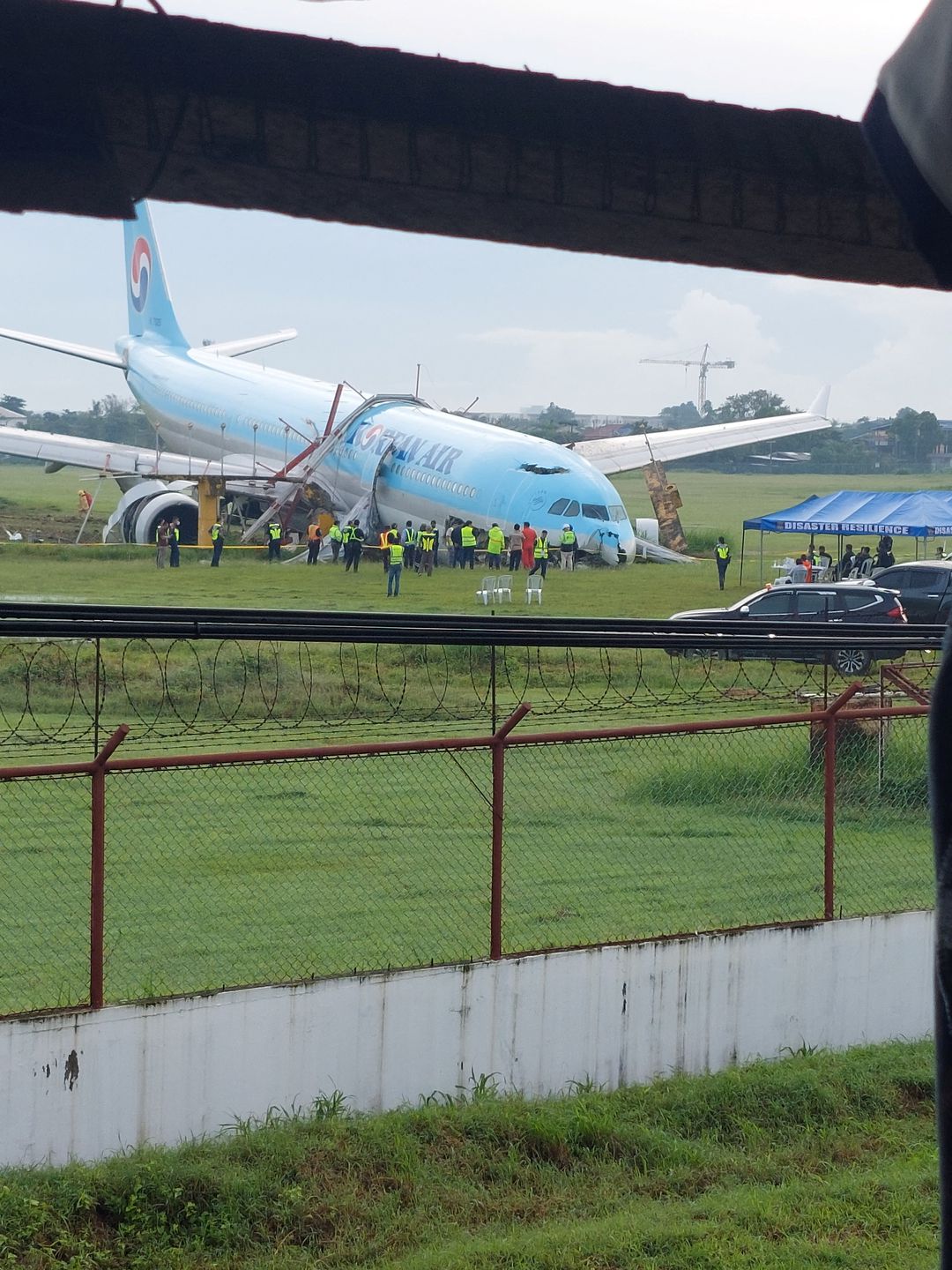 Response crews gather around a Korean Air Airbus A330 widebody flying from Seoul to Cebu, which tried to land twice in poor weather before it overran the runway on the third attempt on Sunday, in Lapu-Lapu City, Cebu, the Philippines on Oct. 24, 2022 in this picture obtained from social media.