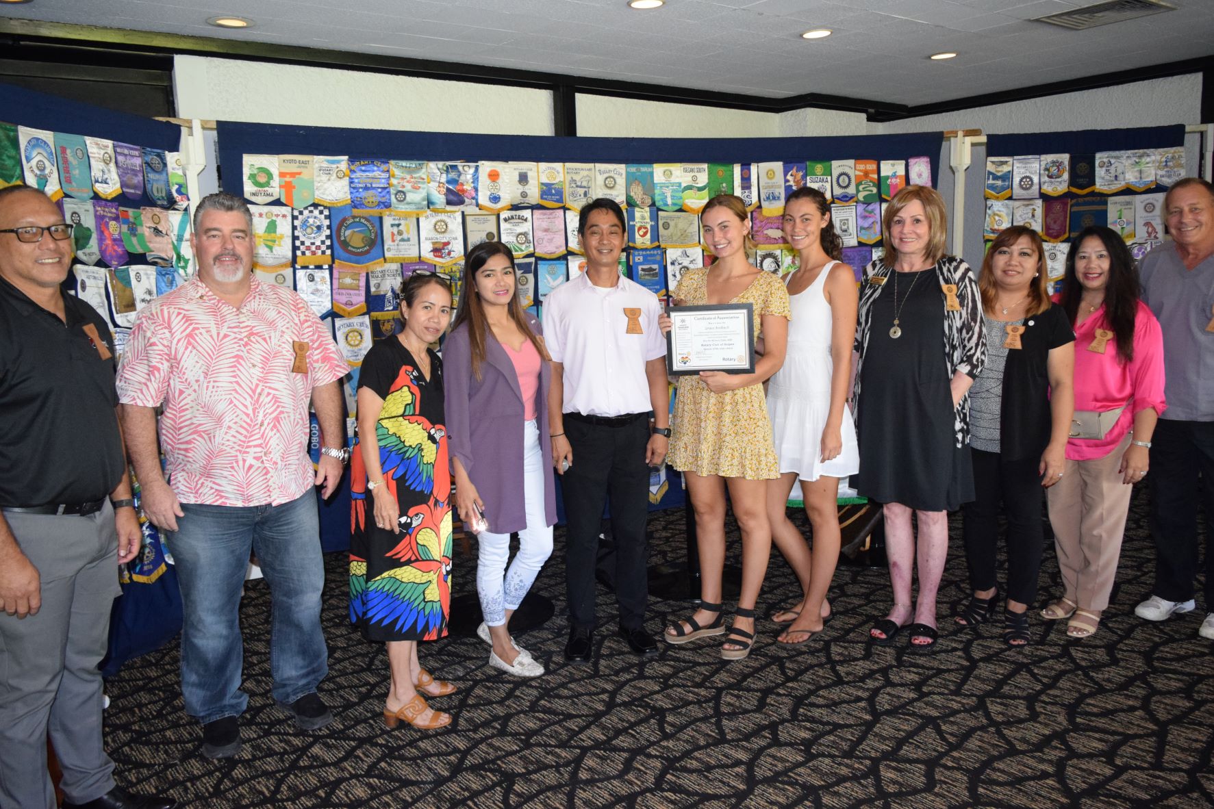 Boonie Babies Saipan co-founder Grace Keilbach, center, holds a certificate of appreciation, as she and her sister and co-founder, Aria, fifth right, pose for a photo with Rotary Club of Saipan President Wendell Posadas, fifth left, and other Rotarians at the Hyatt’s Giovanni’s Restaurant on Tuesday.