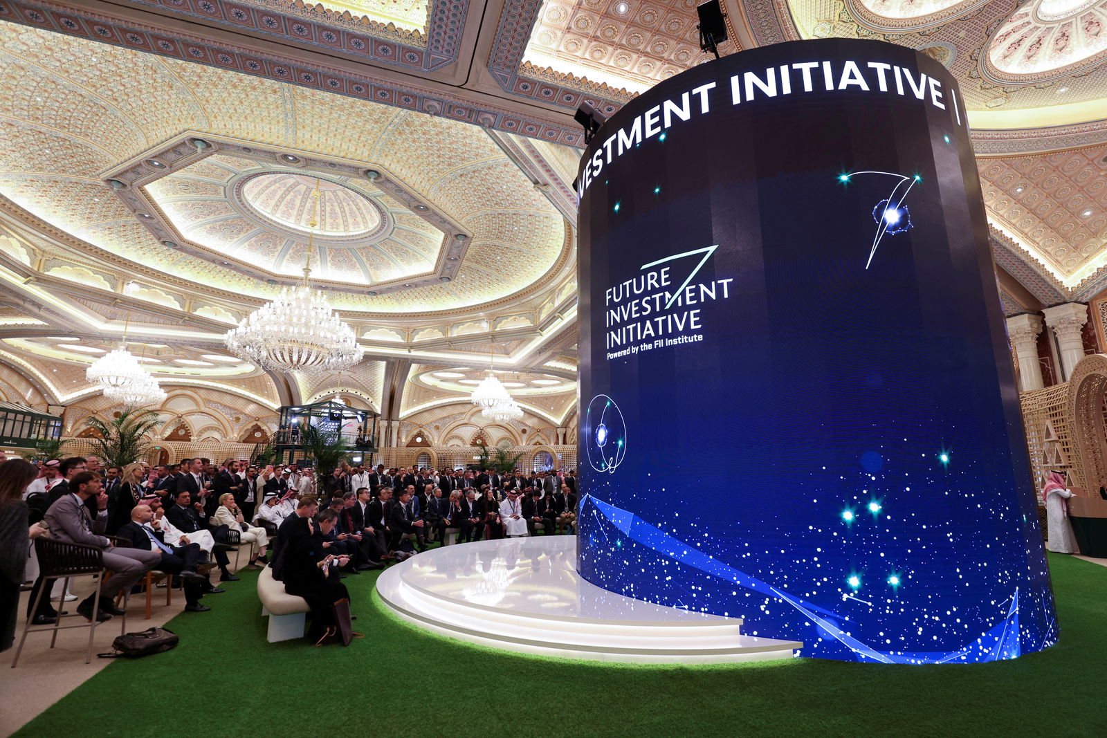 Participants watch the opening ceremony of the Future Investment Initiative conference on a digital screen in the lobby of the Exhibition and Conference Center at the Ritz Carlton Hotel, in Riyadh, Saudi Arabia, Oct. 25, 2022.