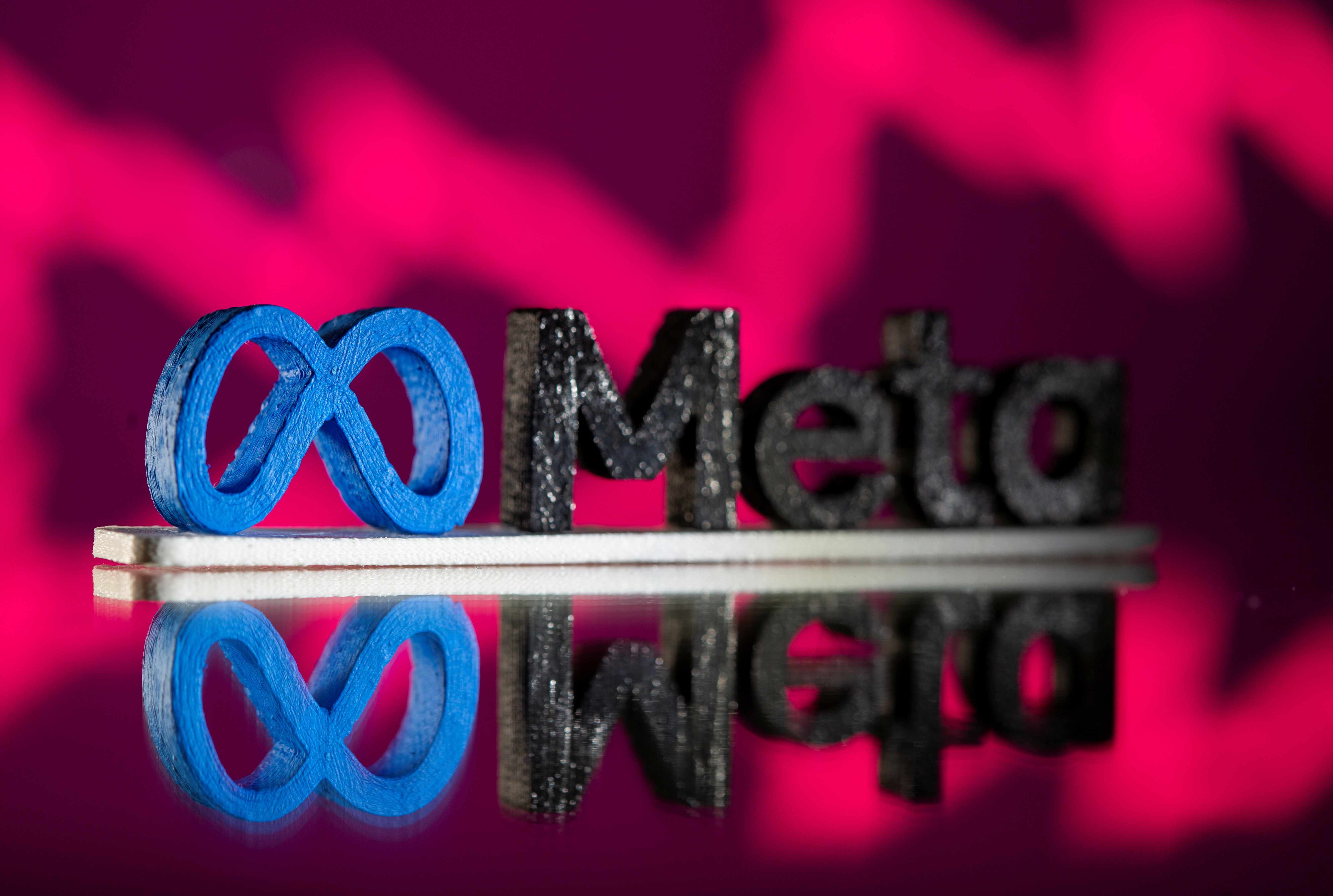 A 3D printed Facebook's new rebrand logo Meta is seen in front of displayed stock graph in this illustration taken on Nov. 2, 2021.