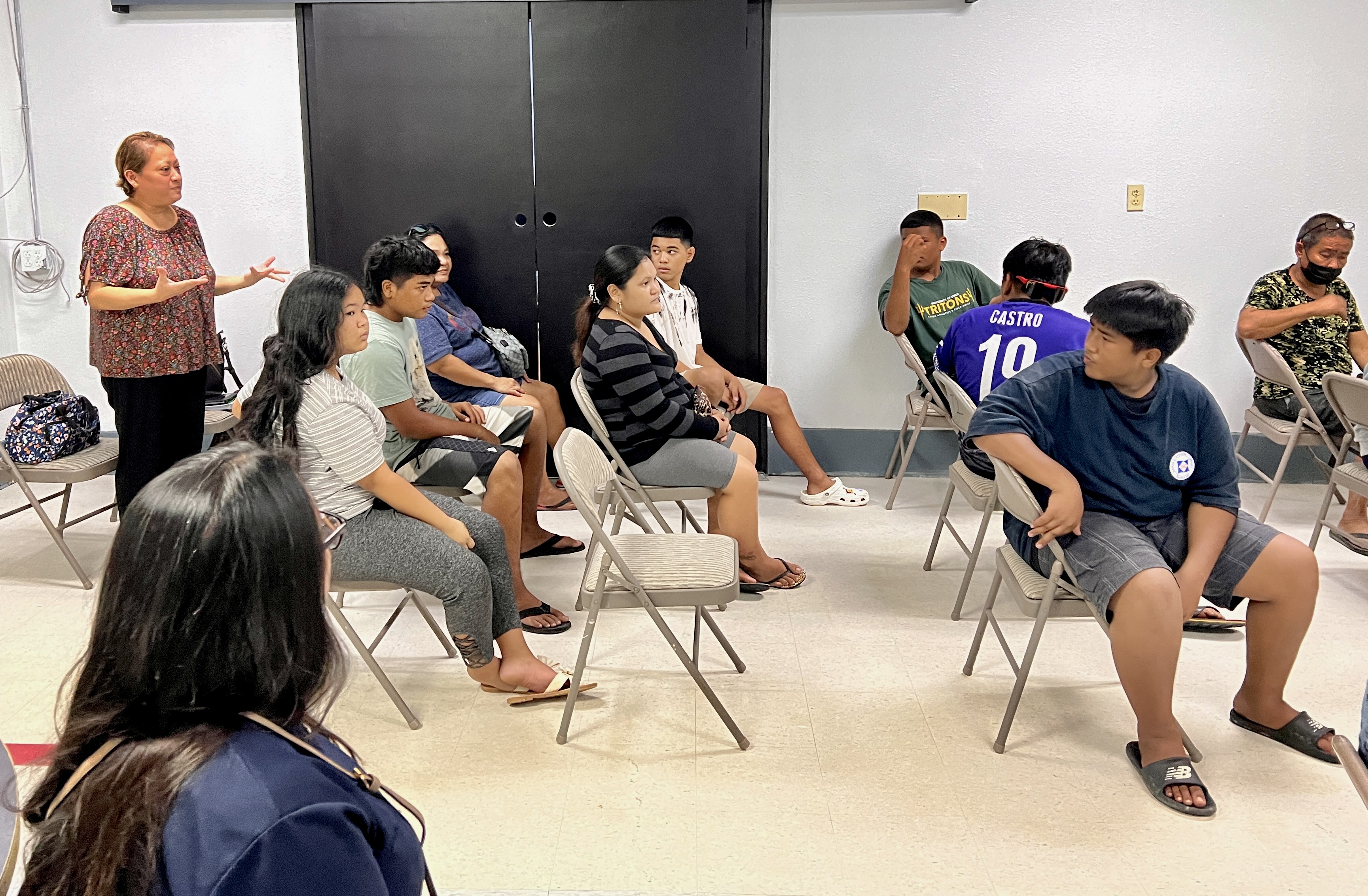 PSS-CTE Program Director Dr. Jessica Taylor, standing left, welcomes the Tanapag Middle School students and their parents during an orientation on Monday evening.